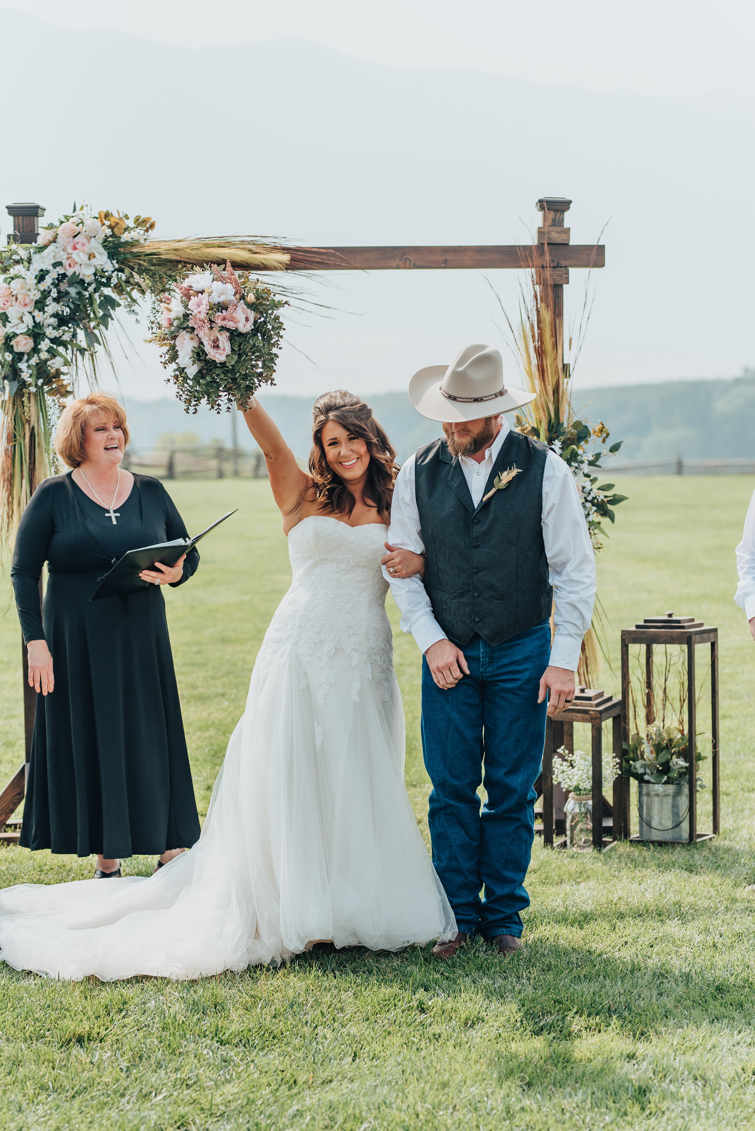  Bride and groom celebrate and cheer as they make their way down the isle of their outdoor ranch wedding ceremony shot by Kristi Alyse Photography in Wellsville, Utah. bride cheering, wedding bouquet in the air, bride and groom smiling while holding 