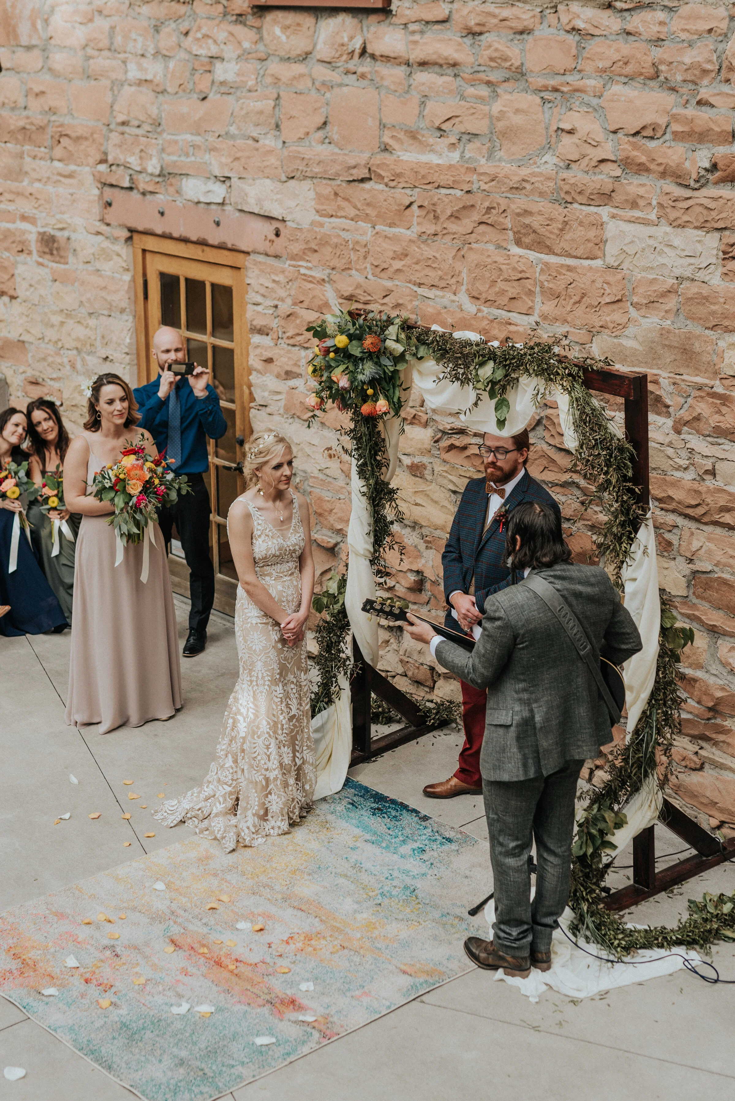 Groom playing guitar for bride during wedding ceremony in a outdoor boho wedding in Salt Lake City by Kristi Alyse Photography. ideas to do during ceremony how to make your wedding ceremony special songs to play during wedding guitars for wedding gr