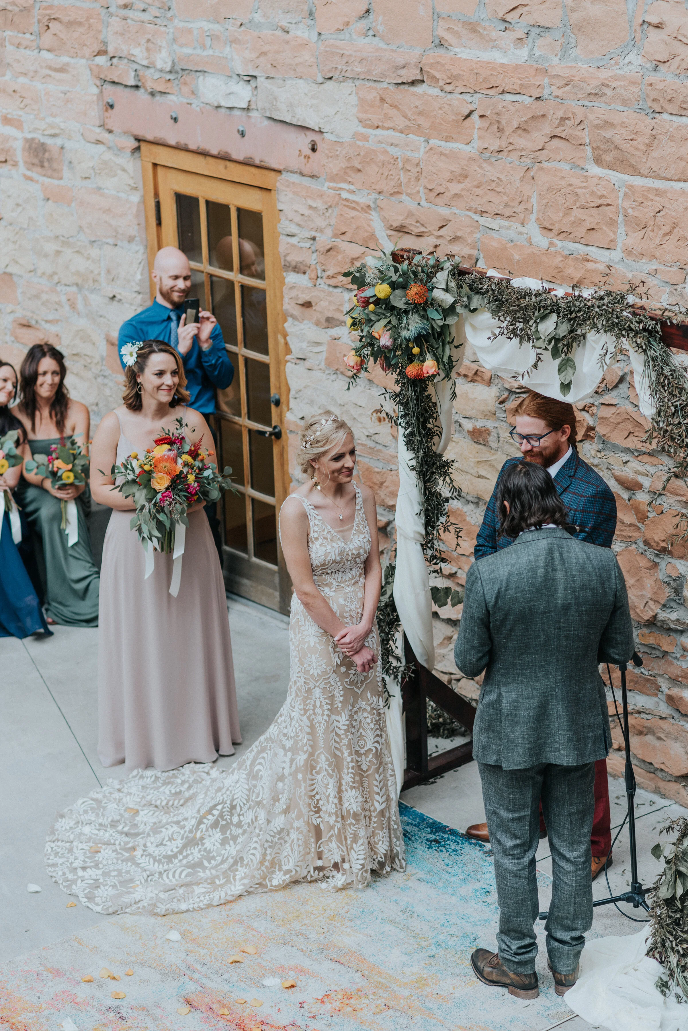  Beautiful boho wedding altar in an outdoor amphitheater with a boho rug and a wood square archway covered in flowers by Kristi Alyse Photography in Northern Utah. how to decorate for boho wedding altar ideas for boho wedding rugs for wedding flower 