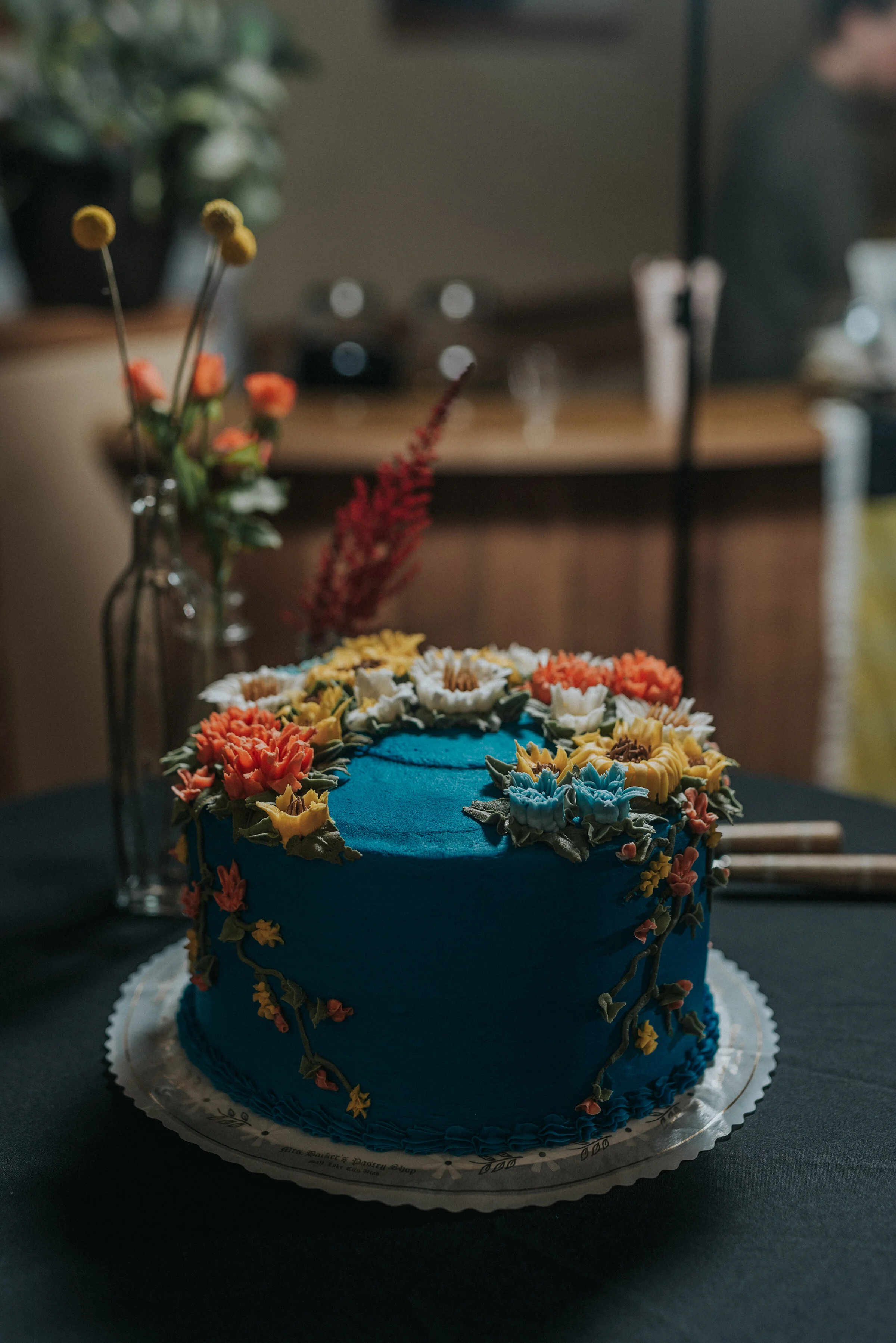  Beautiful boho wedding cake that is blue with fondant flowers on in Salt Lake City by Kristi Alyse Photography. wedding cake inspo for wedding boho wedding cakes unique wedding cakes blue wedding cakes blue wedding colors orange and yellow wedding c