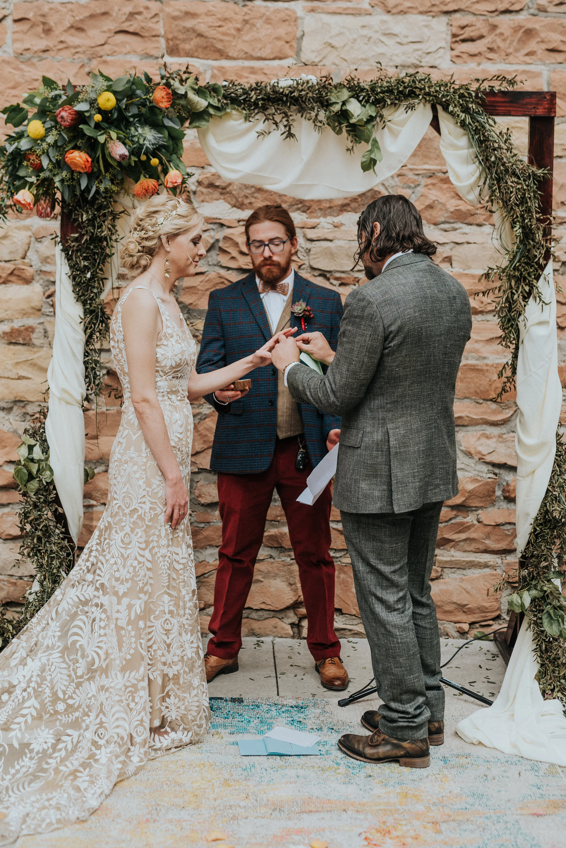  Bride and groom getting married at an outdoor wood altar covered in orange and yellow flowers in Northern Utah by Kristi Alyse Photography. how to decorate for outdoor wedding boho wedding decor ideas best outdoor wedding venues in salt lake city wh