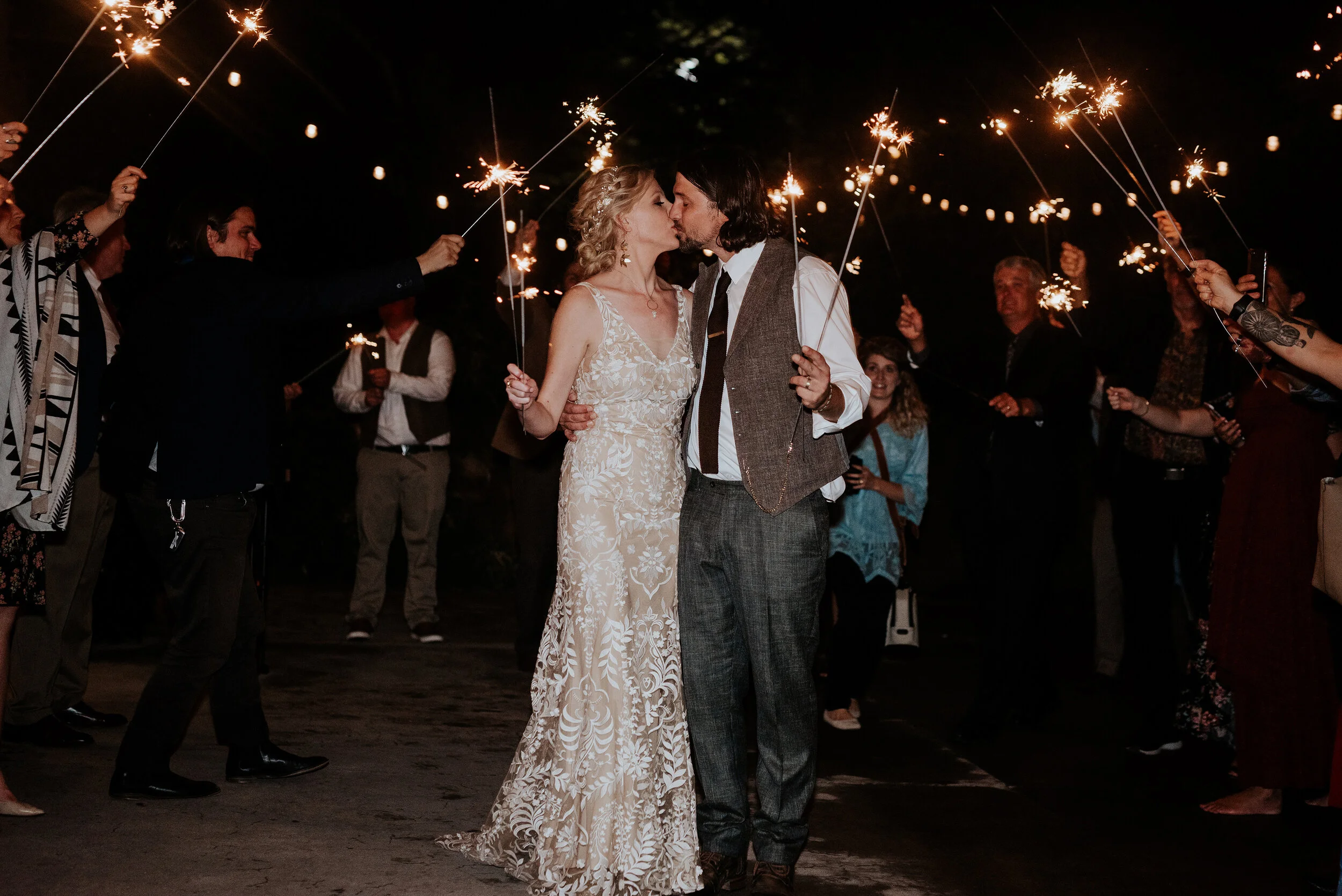  Groom and bride holding sparklers while kissing during their wedding exit in Northern Utah by Kristi Alyse Photography. how to plan a wedding ideas for your wedding how to exit a wedding sparklers at a wedding best things to do at a wedding boho chi