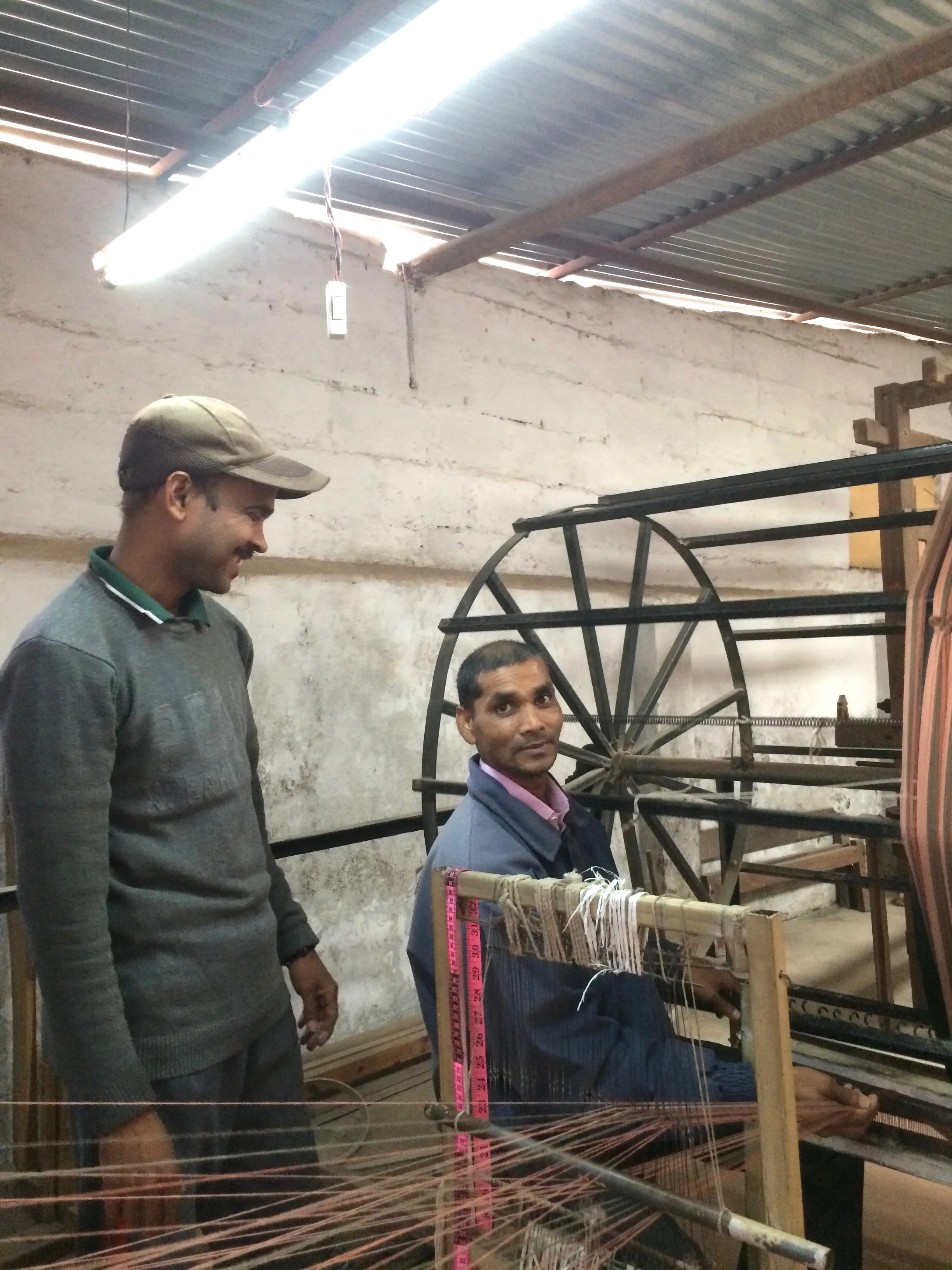In this photo, Kisor (seated) and Padam share a light moment while preparing the warp.
