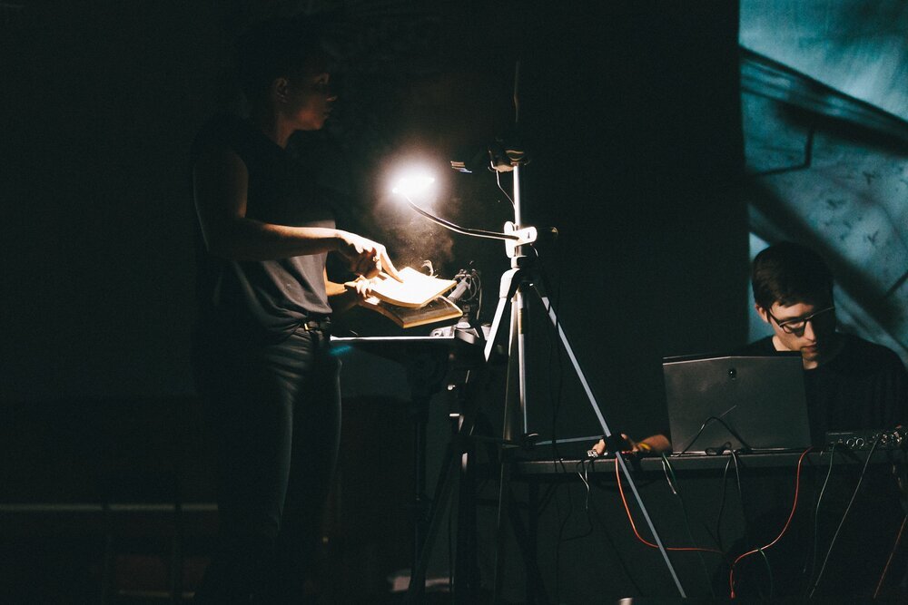Ash Arder carding fiber under a camera, the captured image being manipulated for projection