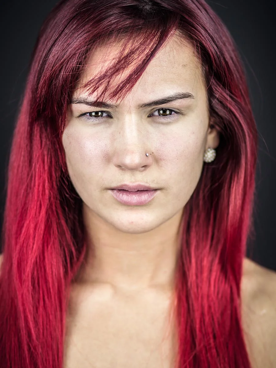 This series of Raw Portraits (Mugs) was created to show the raw beauty of humans. As people were coming in for headshots, I asked them to sit in front of the camera without having any makeup applied, without their hair being done. Then with simple post processing the texture was brought out and skin was slightly desaturated.