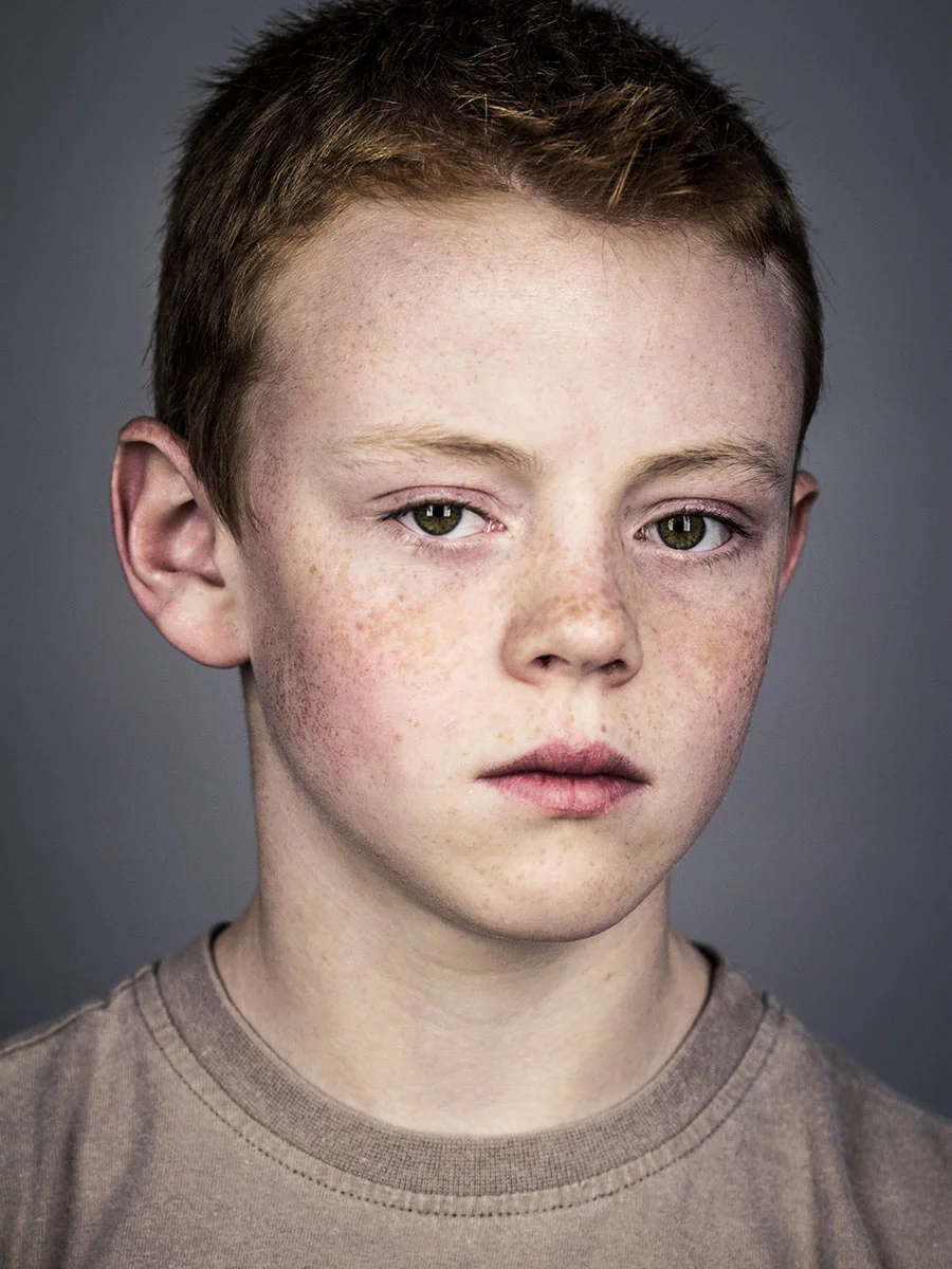 This series of Raw Portraits (Mugs) was created to show the raw beauty of humans. As people were coming in for headshots, I asked them to sit in front of the camera without having any makeup applied, without their hair being done. Then with simple post processing the texture was brought out and skin was slightly desaturated.