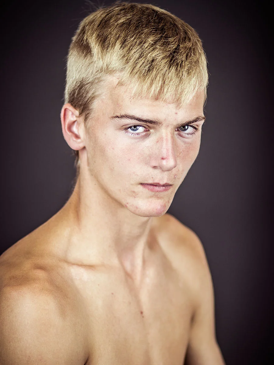 This series of Raw Portraits (Mugs) was created to show the raw beauty of humans. As people were coming in for headshots, I asked them to sit in front of the camera without having any makeup applied, without their hair being done. Then with simple post processing the texture was brought out and skin was slightly desaturated.