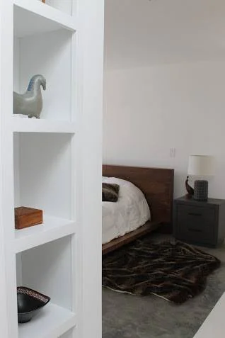 A peek into the master bedroom reveals a reclaimed wood bed and low nightstands.