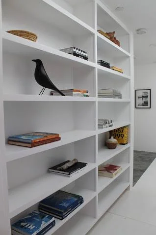 An Eames House Bird appears to have found his rightful place on these modern bookshelves.