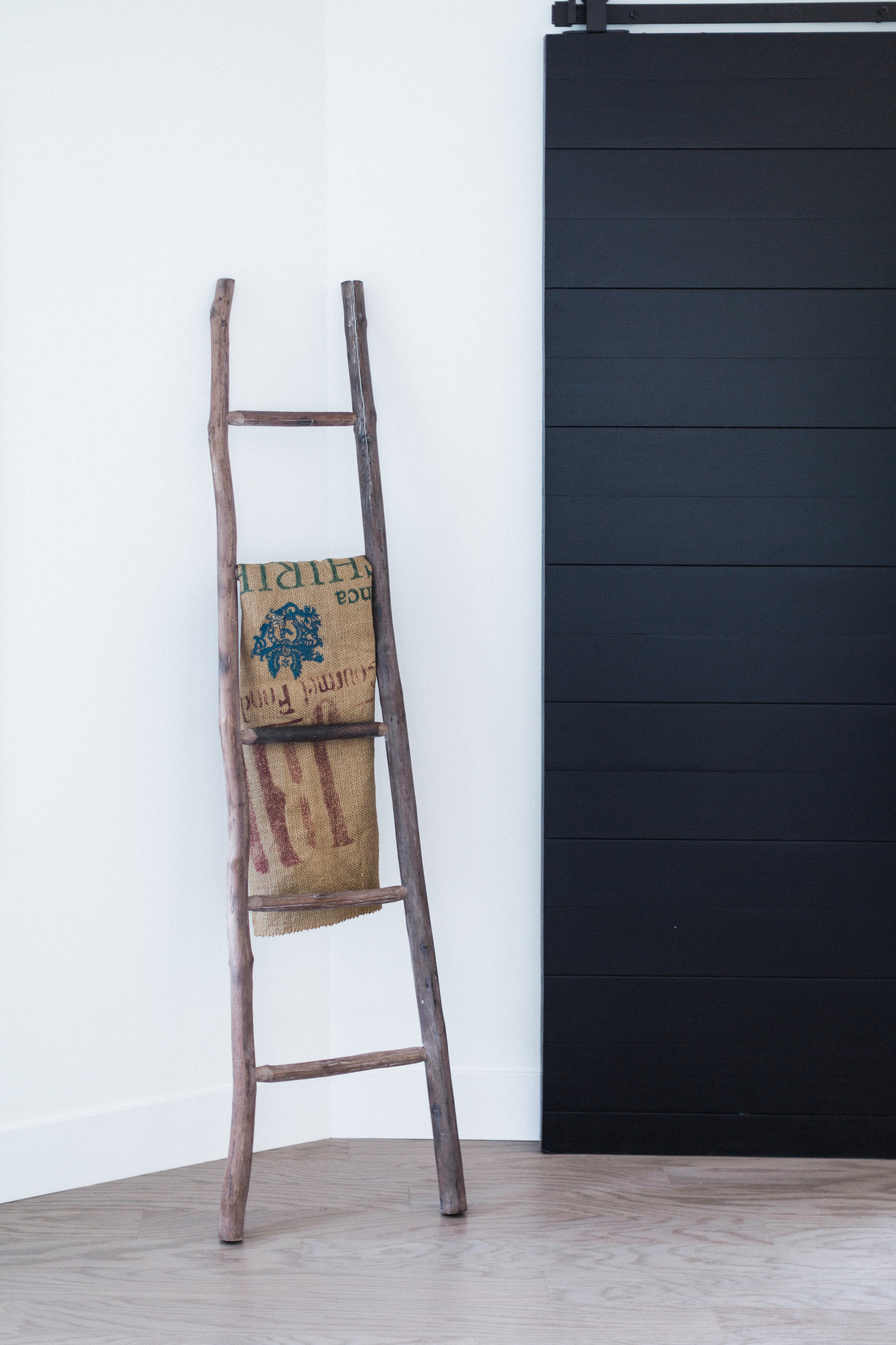 We'll move on to other rooms soon, but pretty please look at this rustic wood ladder next to the rad sliding barn door our client used. A burlap coffee sack is casually placed there as if by accident (riiiiiiiiggghhhht).