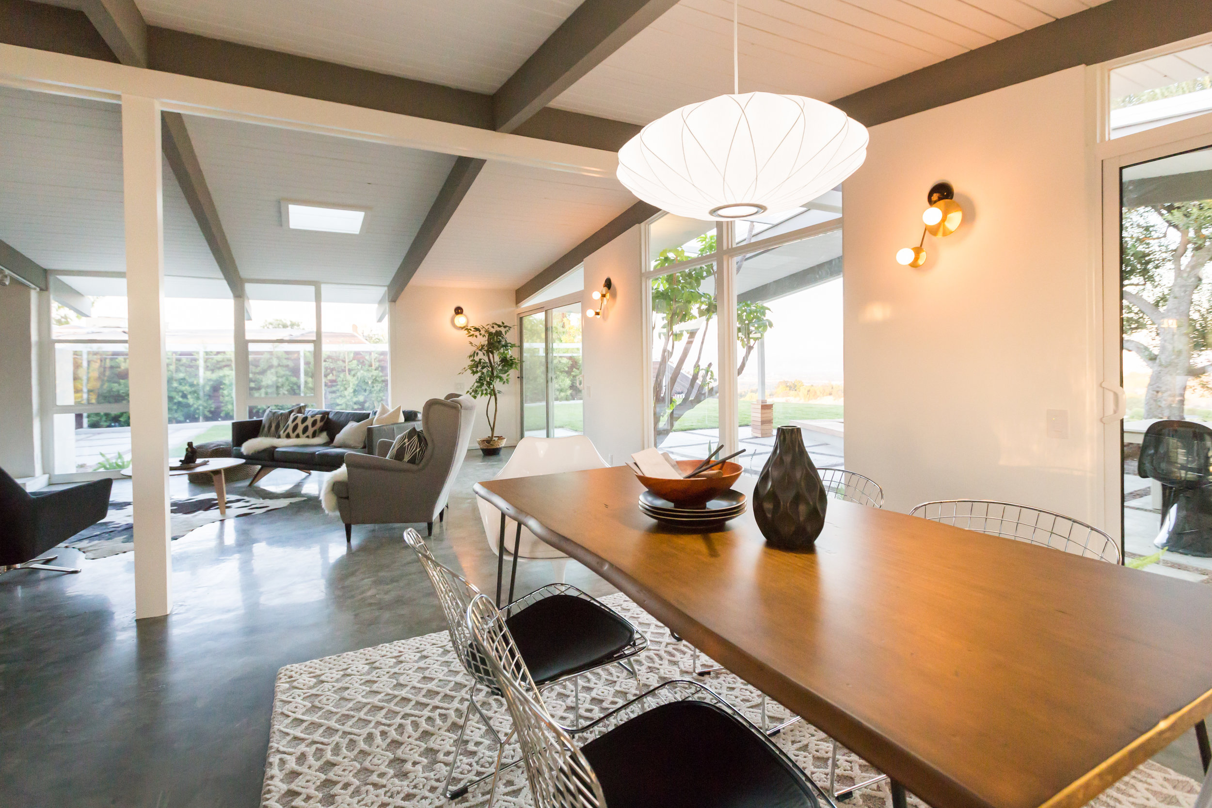 The open-space plan allowed for great flexibility in room layout. Luckily, the Nelson saucer pendant left no doubt as to the placement of the dining table. Bertoia and Saarinen chairs surround a paperclip table from World Market. Underneath, a nubby tribal pattern rug.
