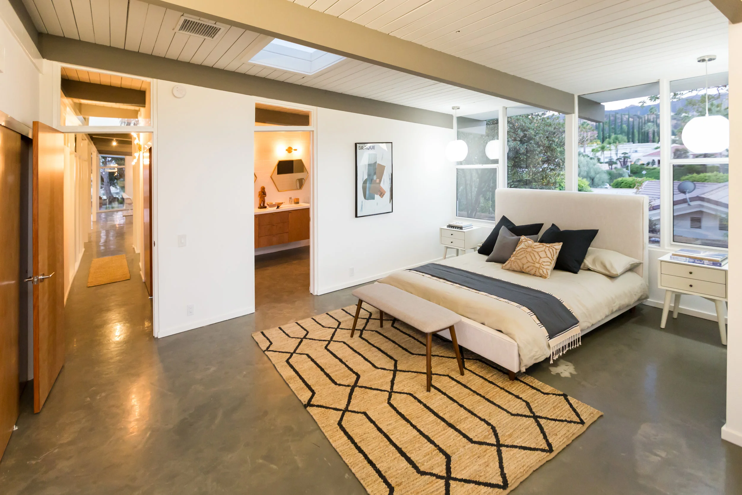 The master bedroom is a study in simplicity and the power of a strong tribal pattern. In this case, a jute rug.
