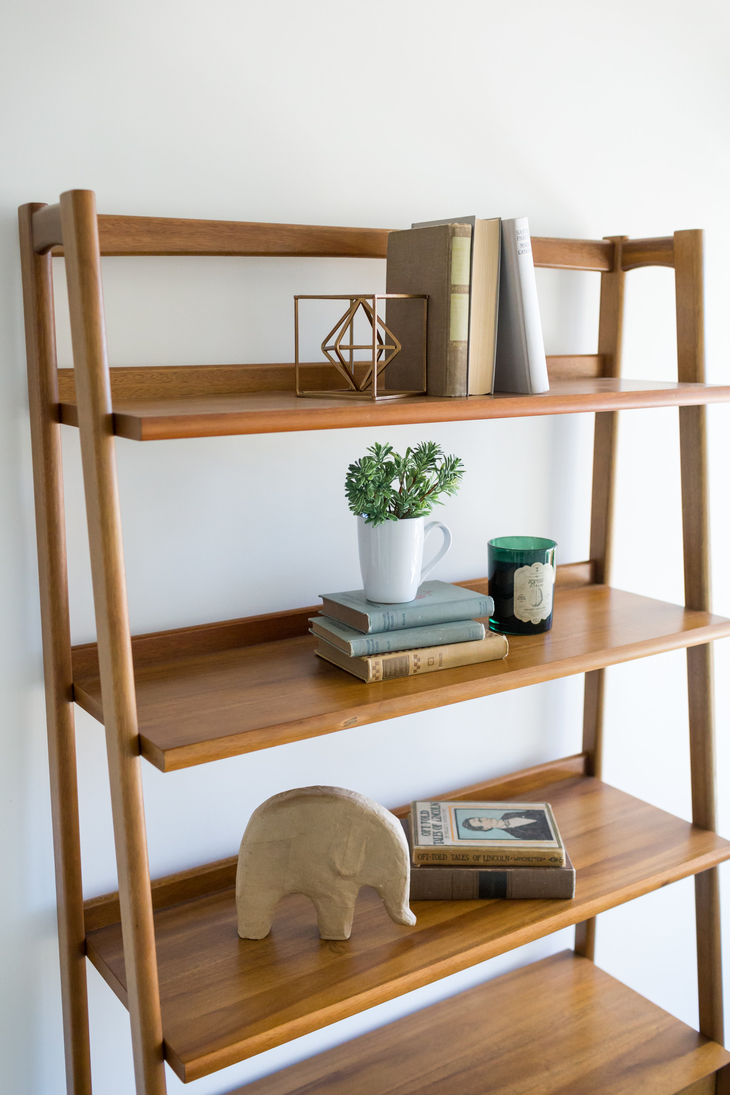 Neutral, modern shapes and vintage books fill out the shelves.