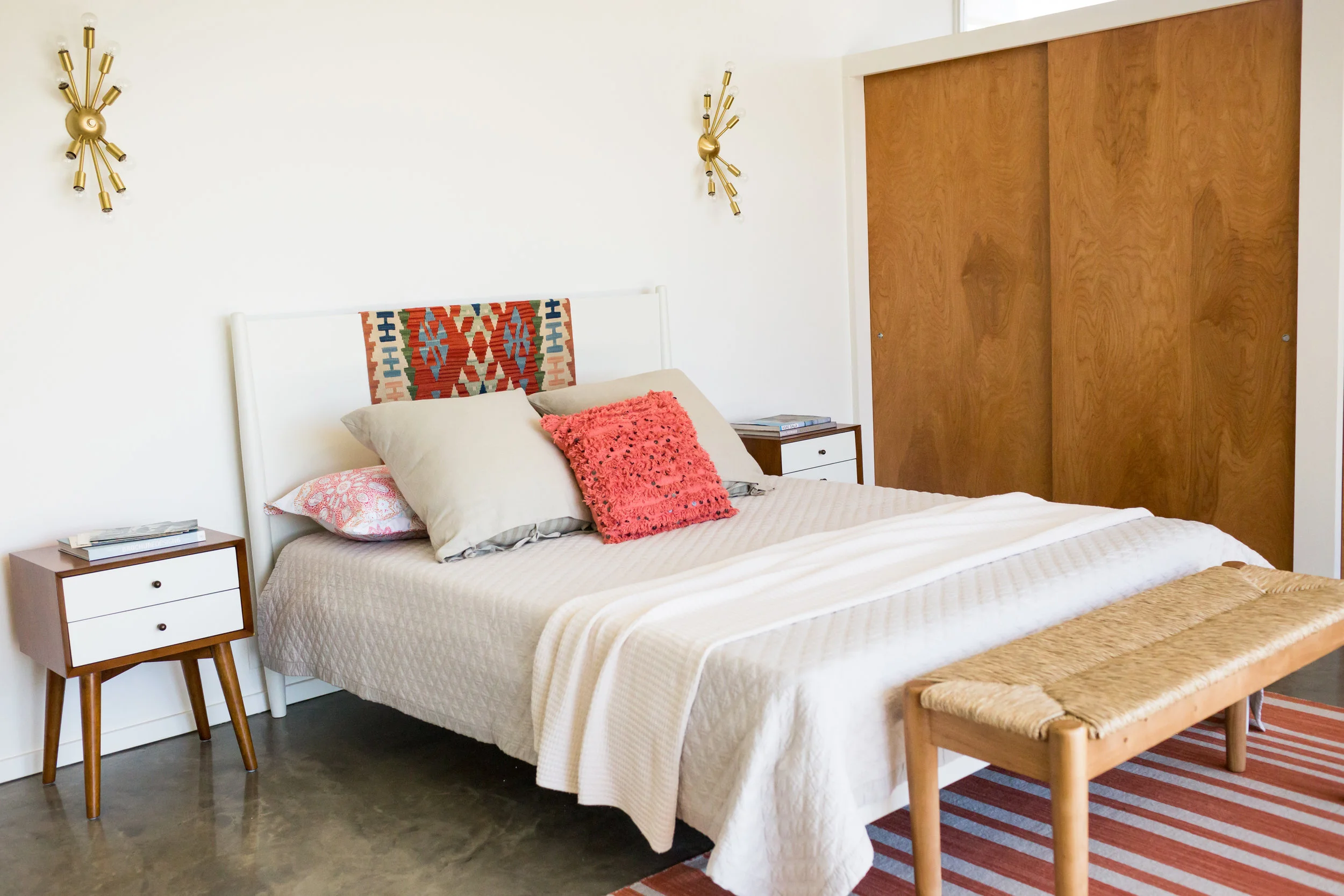 Salmon tones in a second bedroom. A vintage kilim rug found in Paris serves to brighten a wooden headboard.