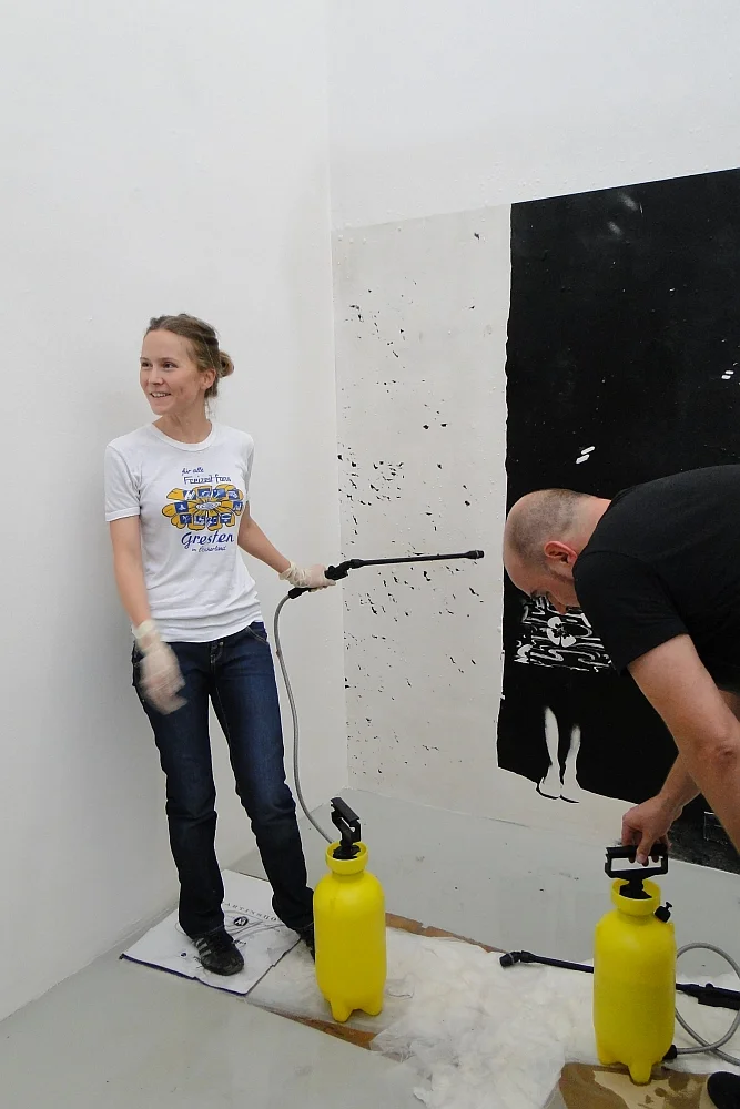 Brigit Graschopf, bei der Performance in der Galerie Momentum mit Schlauch in der Hand, 2011