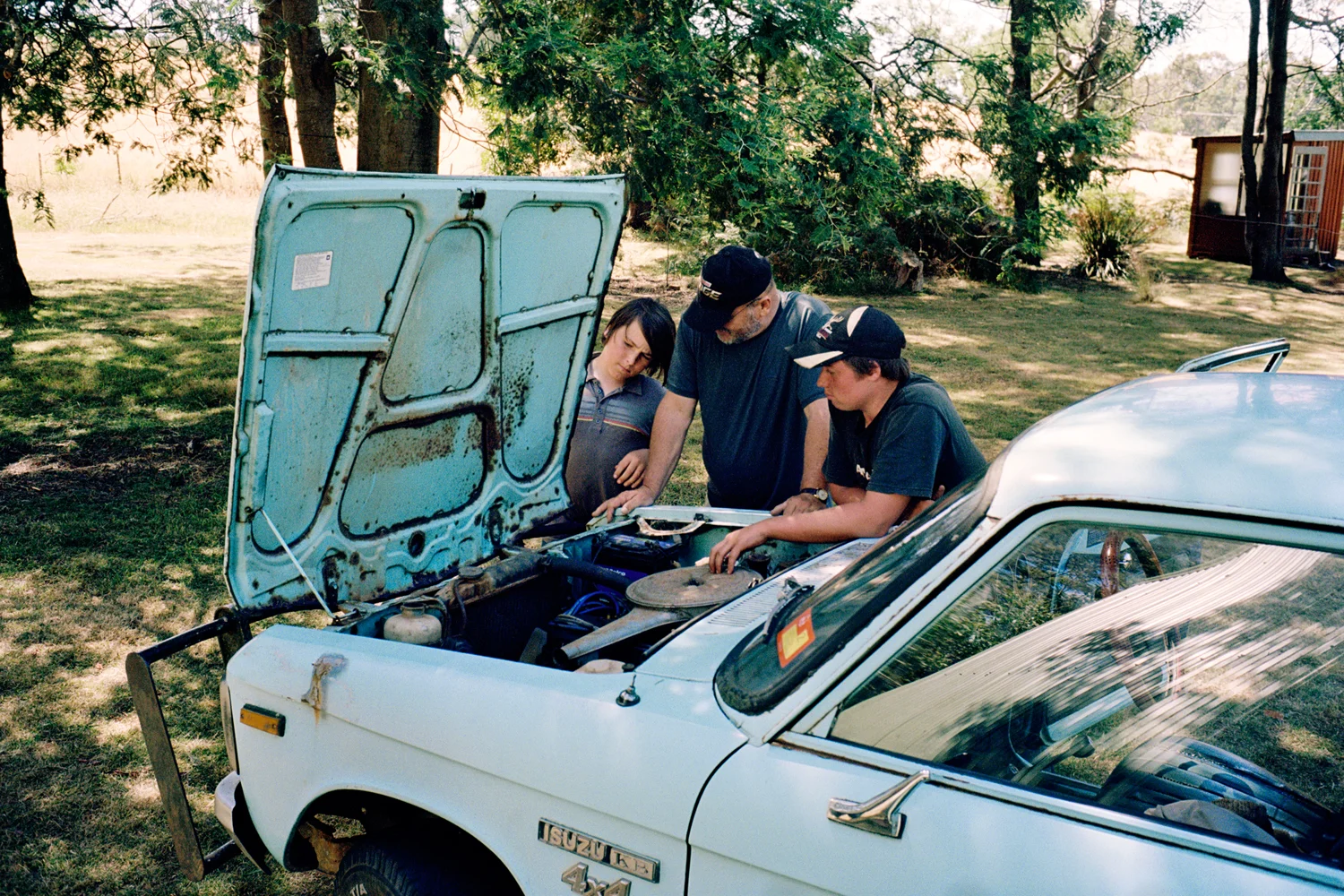 "Home education is an integrated way of learning that takes on real life situations. We consciously make a point of looking for individuals within our community who have something to offer. Our children have interacted with a diversity of people doing various trades and skills, opportunities children in mainstream school could never have had." Issy and Mark Ulbrich with their neighbour and mechanic David Wilson. Reedy Marsh, Tasmania.