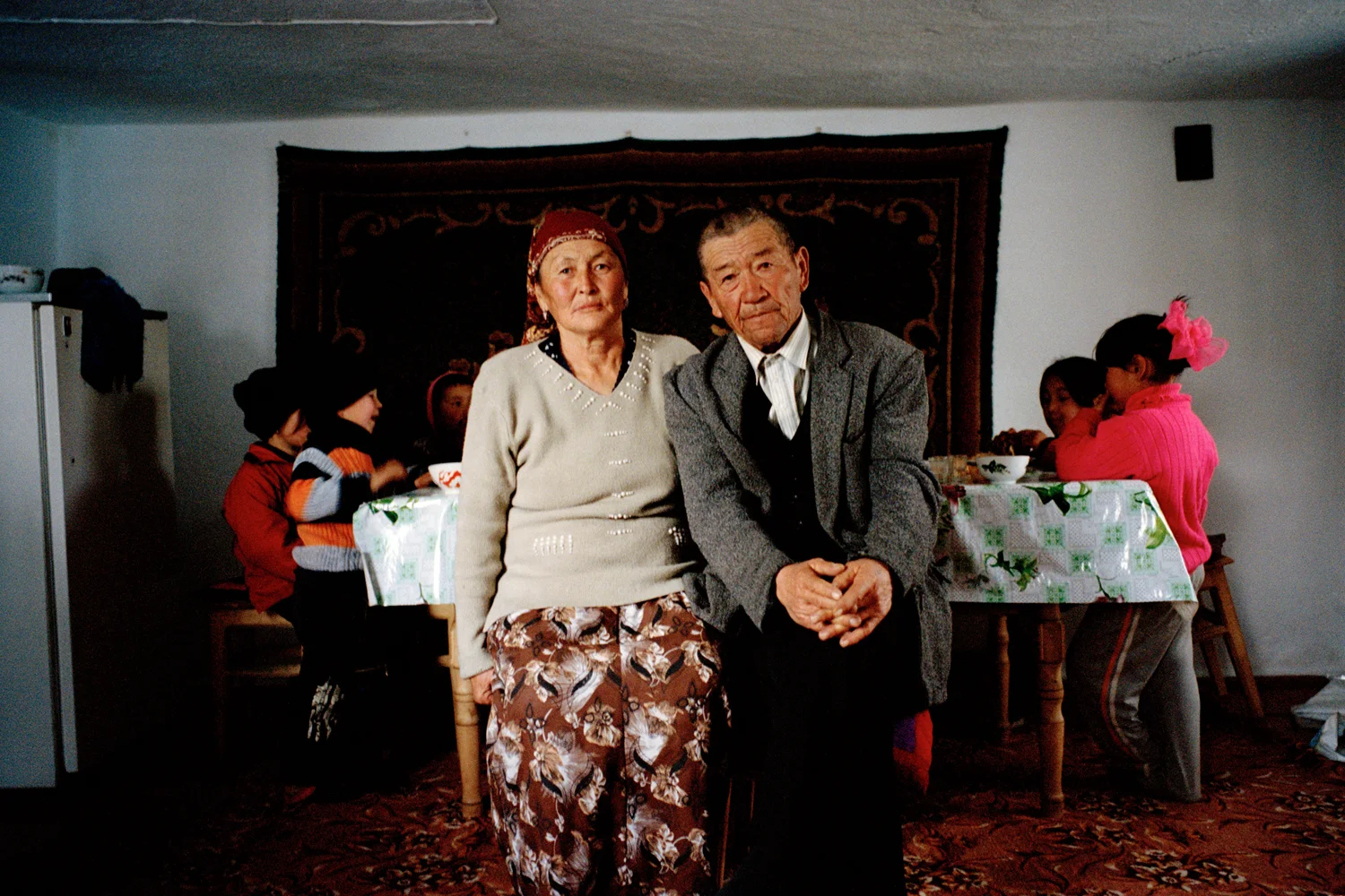 Omurbai and Meerkan on the third day of hosting over 160 guests in their house to visit their new daughter-in-law who was recently kidnapped by their son. Omurbai has just returned from visiting the girl’s family to beg forgiveness for the kidnap and to offer gifts as way of compensation. He was welcomed in and the two families celebrated. As a young man Omurbai also kidnapped Meerkan who was from his village. Issyk-Kul Oblast, Kyrgyzstan.