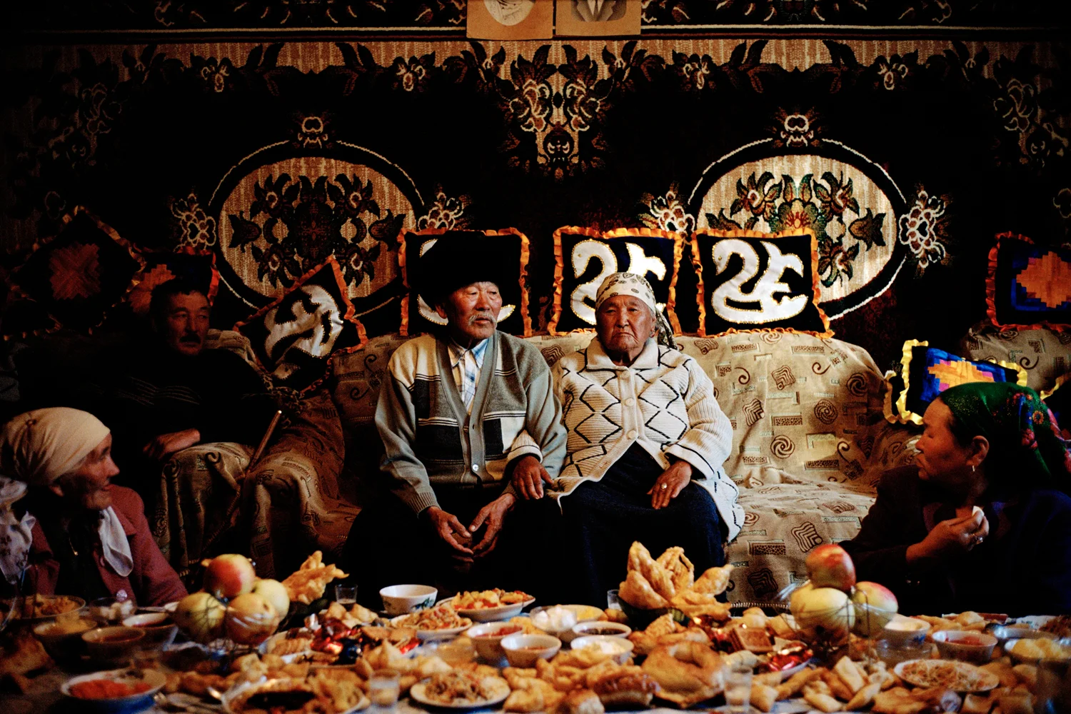 Bekbosun and Bubakan on their 60th wedding anniversary surrounded by their family. Bubakan was kidnapped by Bekbosun on horseback on his 20th birthday as part of the Kyrgyz tradition of bride stealing. Issyk-Kul Oblast, Kyrgyzstan. 