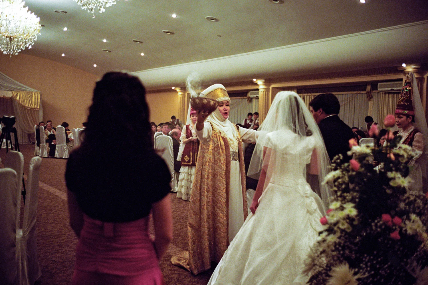 An upper class wedding in the capital Bishkek. The increasing expense of modern weddings is often cited as a reason for kidnapping. The traditional Kyrgyz wedding involving many rituals each accompanied by the exchange of expensive gifts and generous hospitality has been made dearer by the Western additions of a white dress, a photographer and a smart car. Bishkek, Kyrgyzstan.