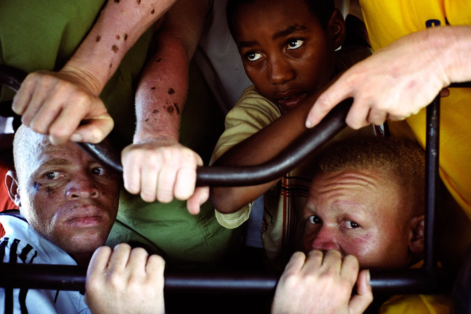 Members of the Albino United football team squeezed into a borrowed van on their way to a match. Football matches are an opportunity for huge crowds to change their attitudes towards people with albinism when they see them playing and wining. Dar es Salaam, Tanzania. 