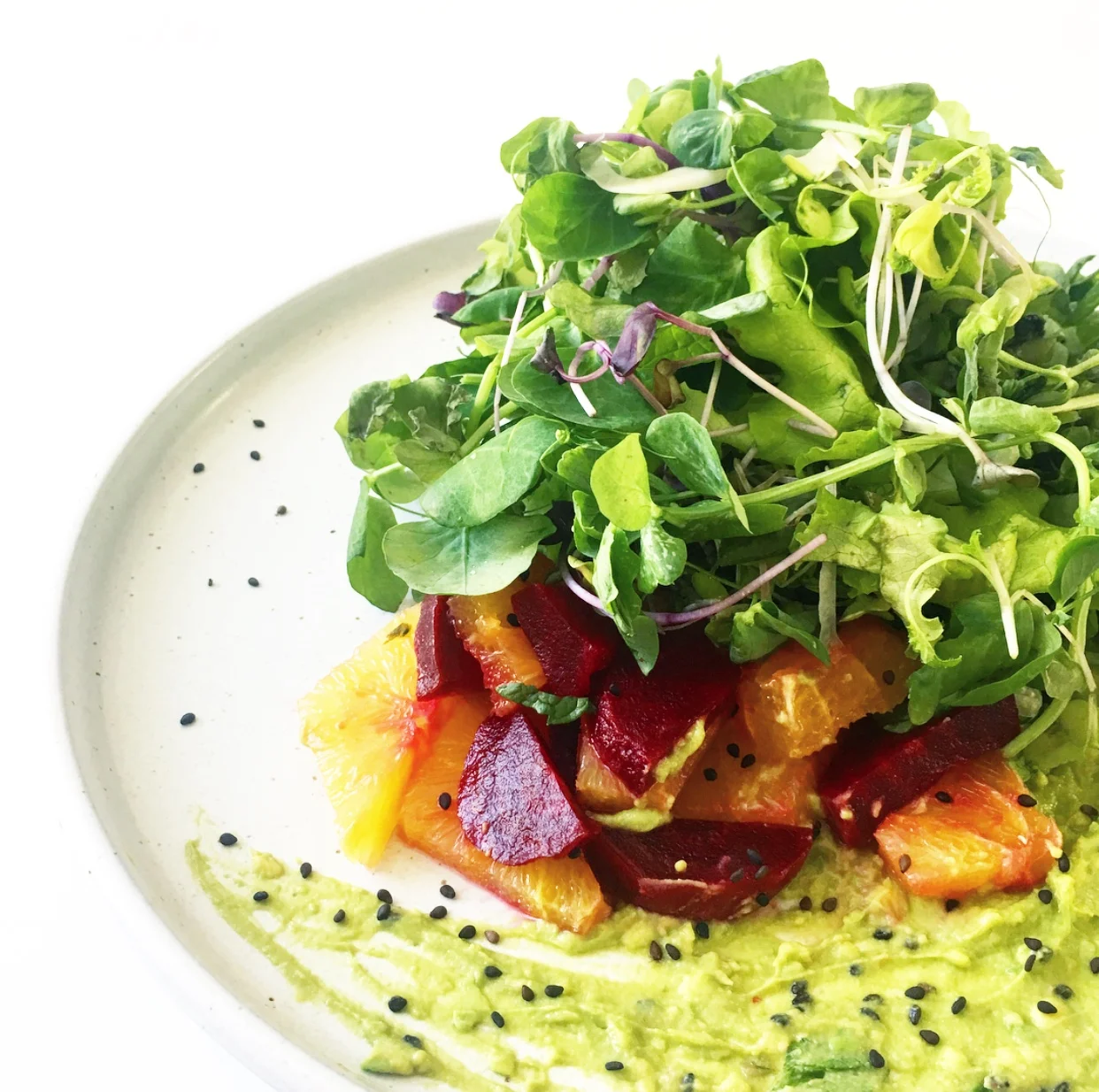 Tangles of local sprouts and greens piled high atop a beautiful medley of beetroot and citrus with a fiery avocado tahini herb dressing —#vegan has never tasted so good. Yum!