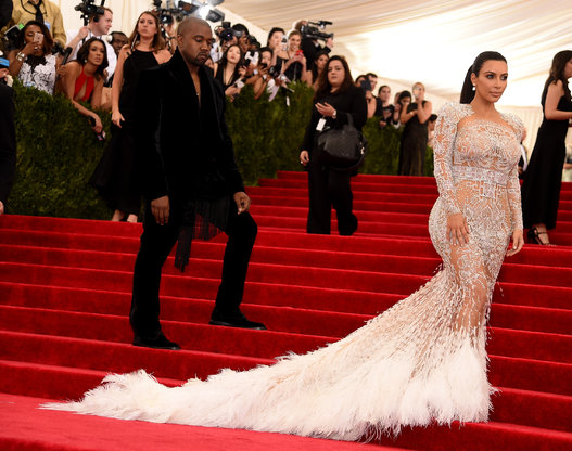  The never smiling Kanye West watches wifey Kim Kardashian take the red carpet in Roberto Cavalli. 