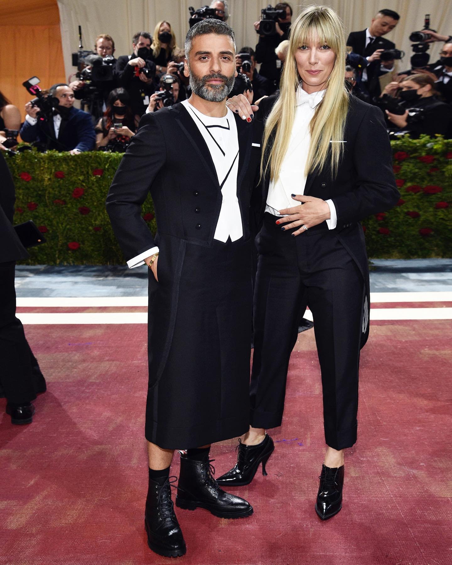 Oscar Isaac wears a white tie and tails trompe l'oeil tailored dress &amp; Elvira Lind wears a black 3-ply mohair tailcoat, classic tailored trousers.