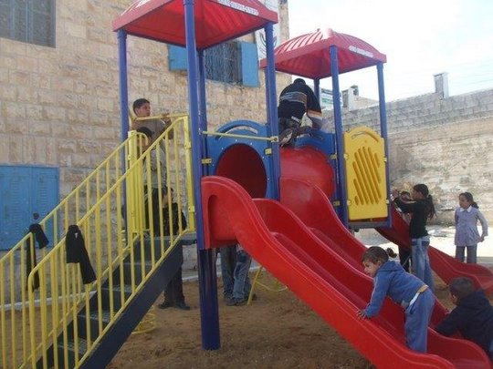 Palestinian children enjoying their new playstructure.