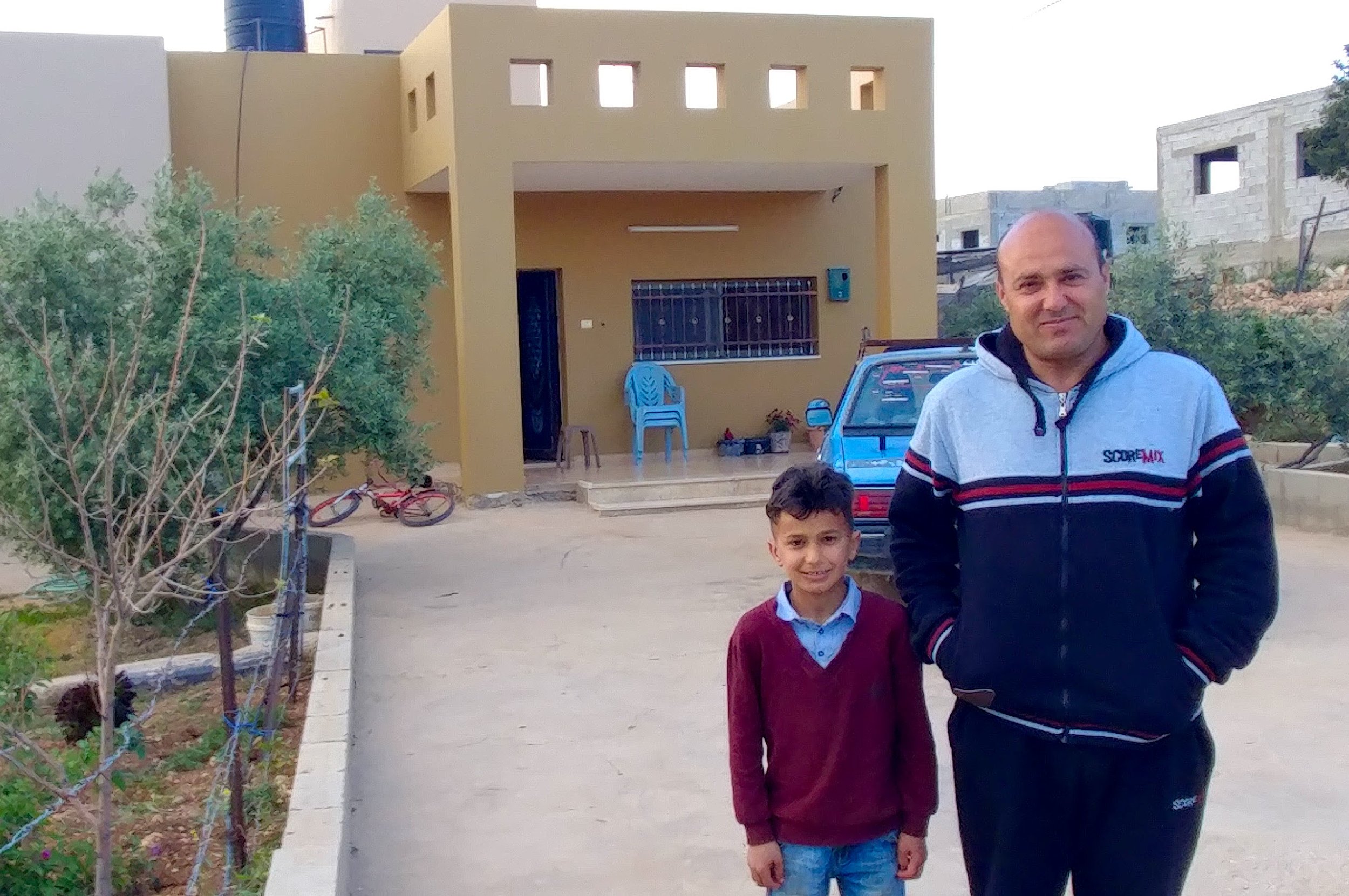 Shady and his father in front of their home