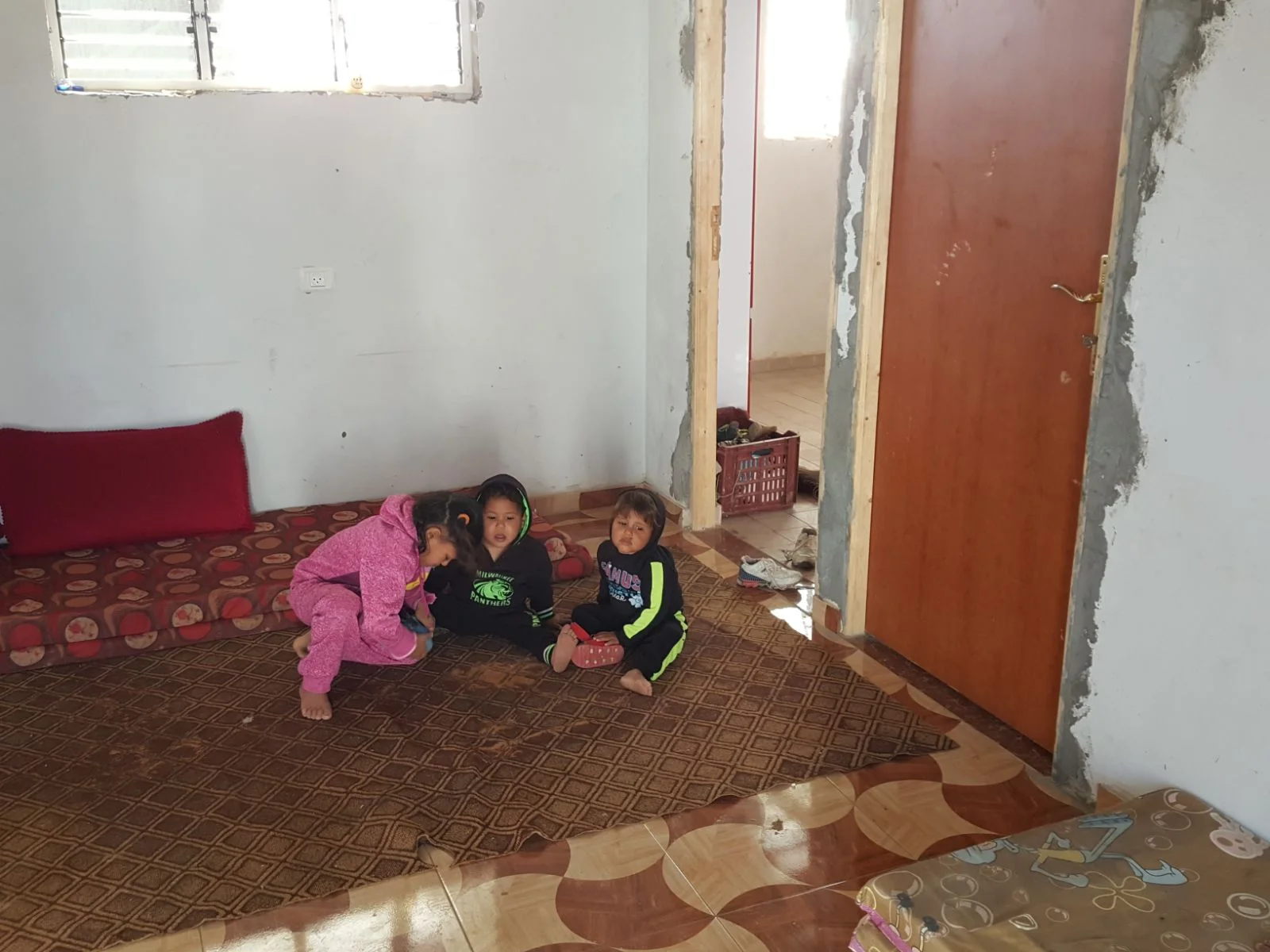 Three of Abeer's children in their cement house. 