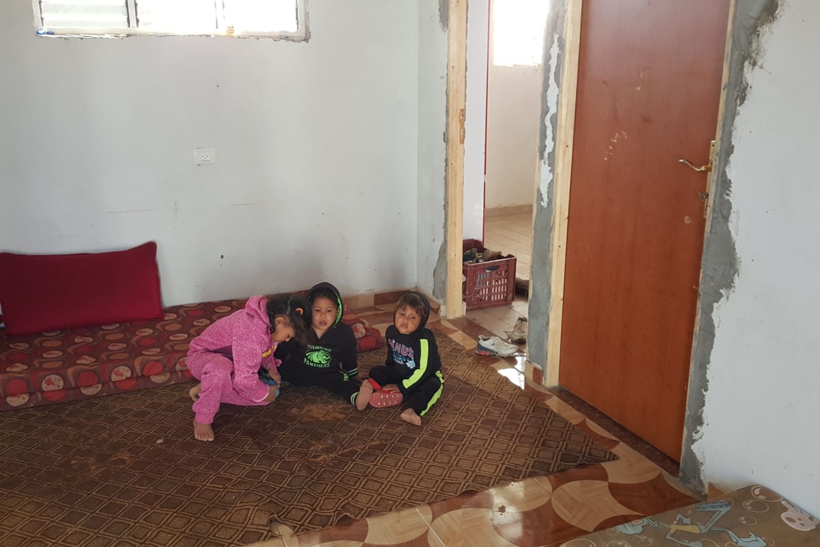 Three of Abeer's children in their cement home.
