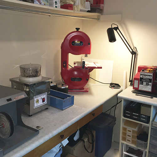 Raw castings go into the magnetic tumbler (grey box) for doing the first general polish. The polishing lathe (far left) does the finishing polish. The red band saw is used to cut material for the CNC machine.