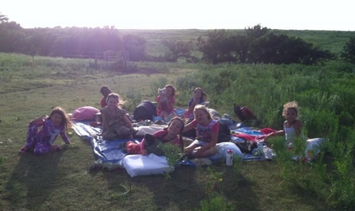 A cabin of girls enjoys an evening camping out on the prairie. Campout night is still a favorite tradition at camp wood.