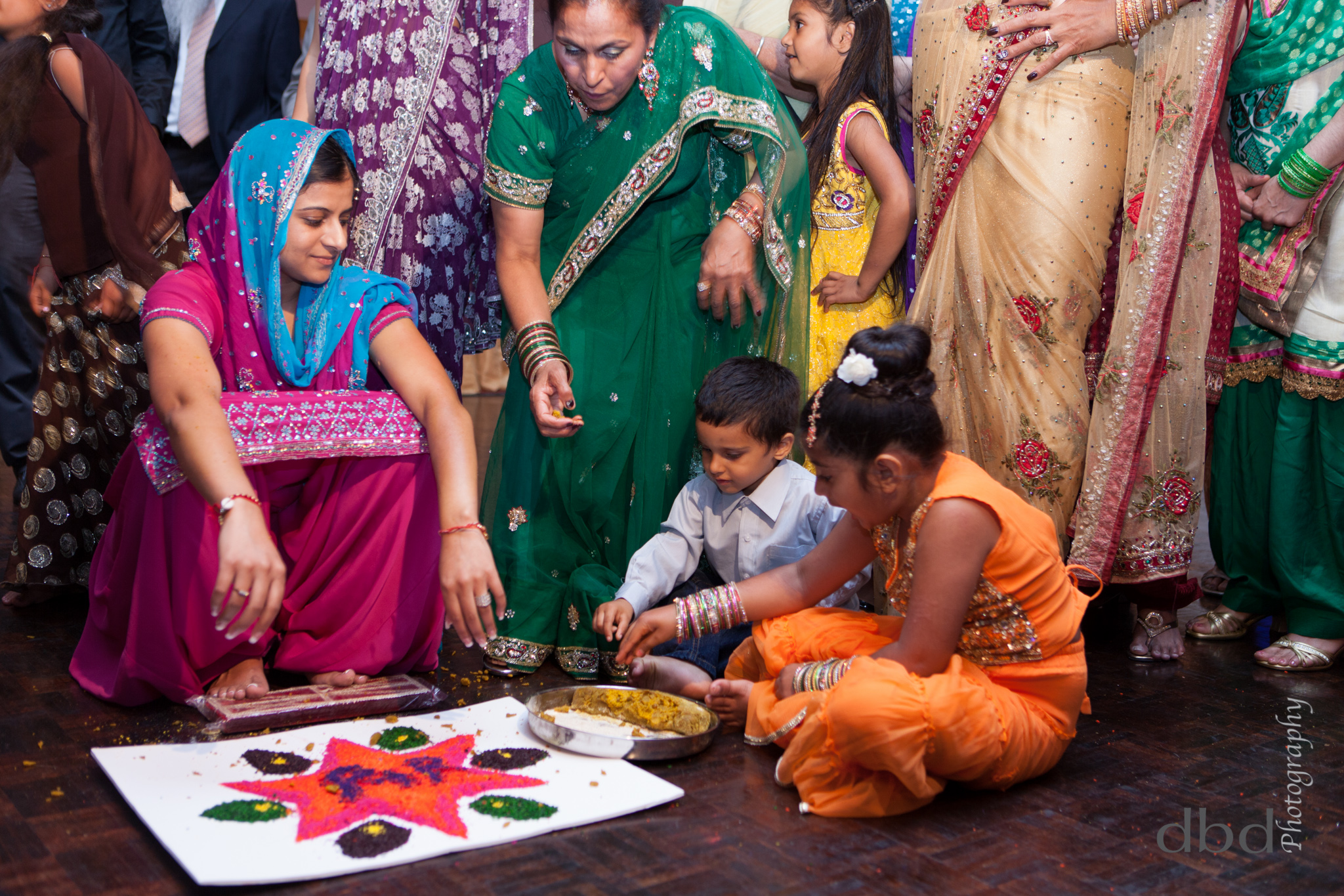  The girl sits in front of the&nbsp; rangoli &nbsp;which has been prepared by her family and friends with some help from the children 