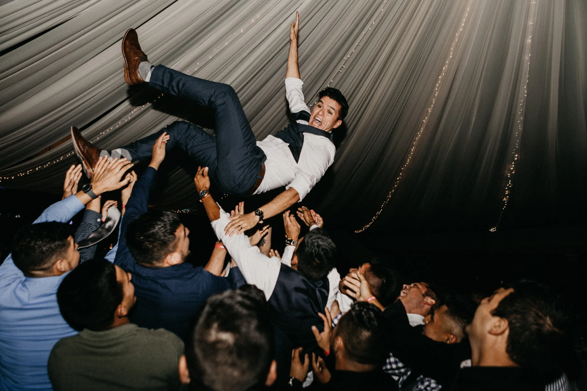 Groom photographed on his wedding day being thrown in the air