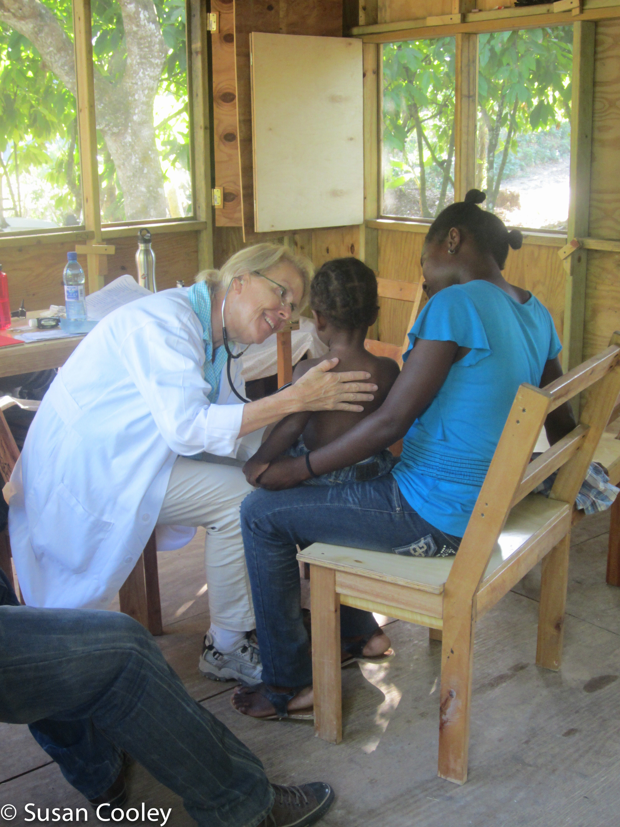 Susan examines clinic patient, 2013.