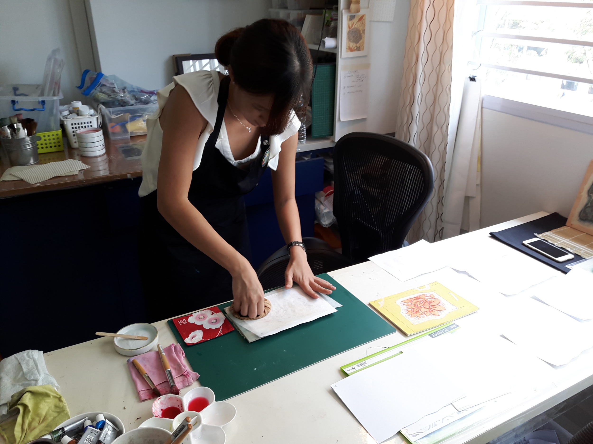 Rubbing the back of the print with a baren. 