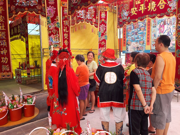 Members from the Wayang Chinese theatre group praying at the set up shrine. 