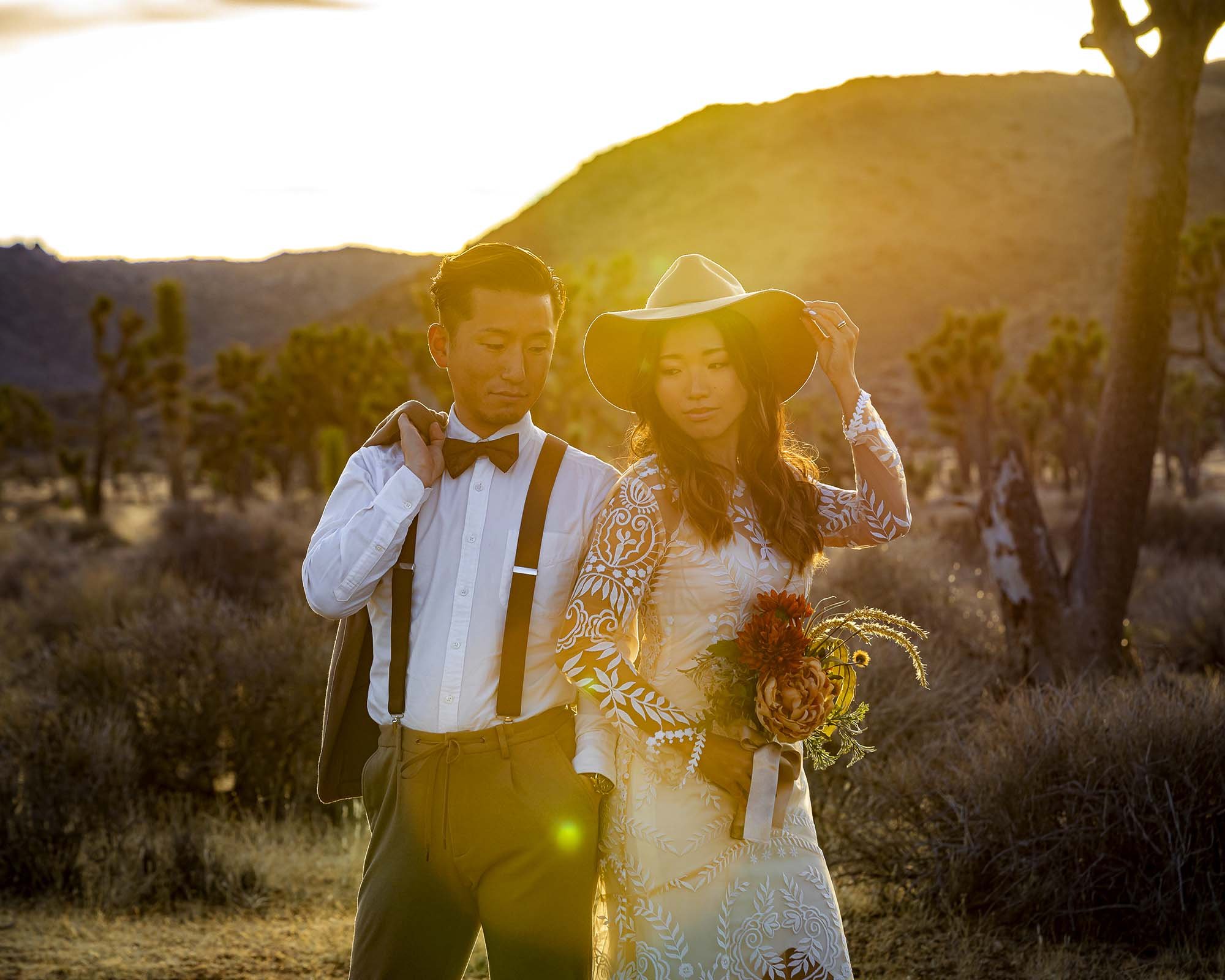 ウェディング撮影でジョシュアツリー国立公園の夕日をバックにたたずむ新郎新婦