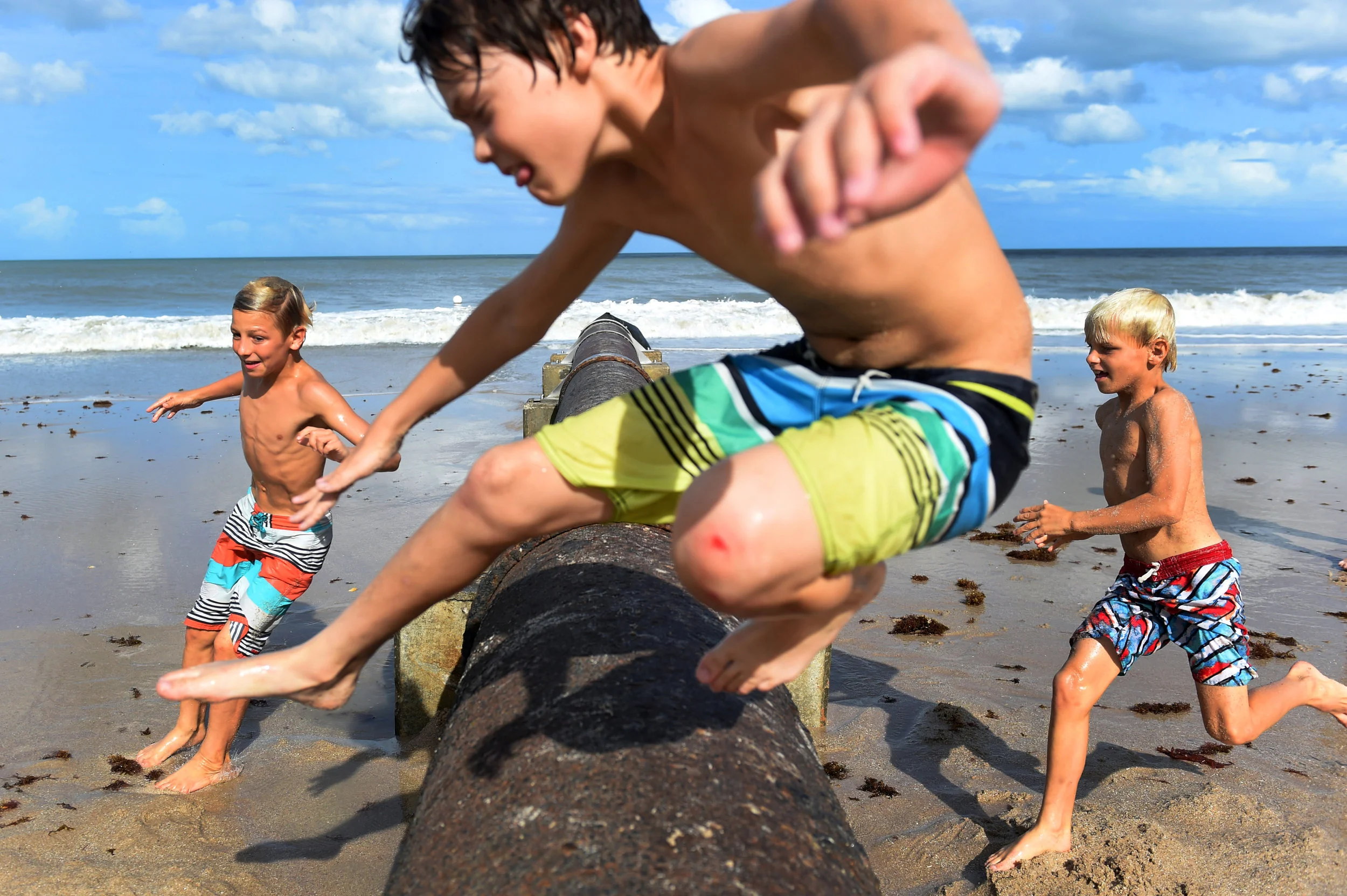  Silas Ferrell, 11, (from left), Hugh Downey, 11, and Noah Ferrell, 8, take turns jumping over a drainage pipe on Humiston Beach in Vero Beach on Monday, Sept. 11, 2017. The pipe was exposed after the sand on the beach eroded due to the high surf and