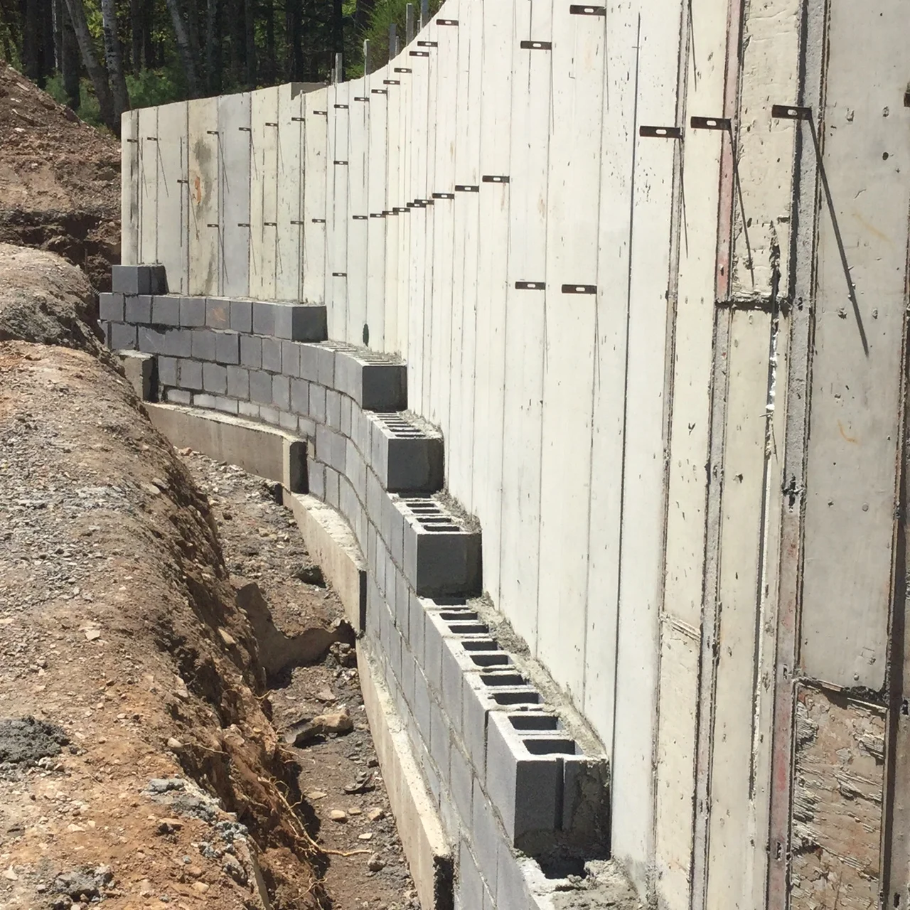 A poured in place concrete wall prepped to receive a "decorative" natural stone facing.