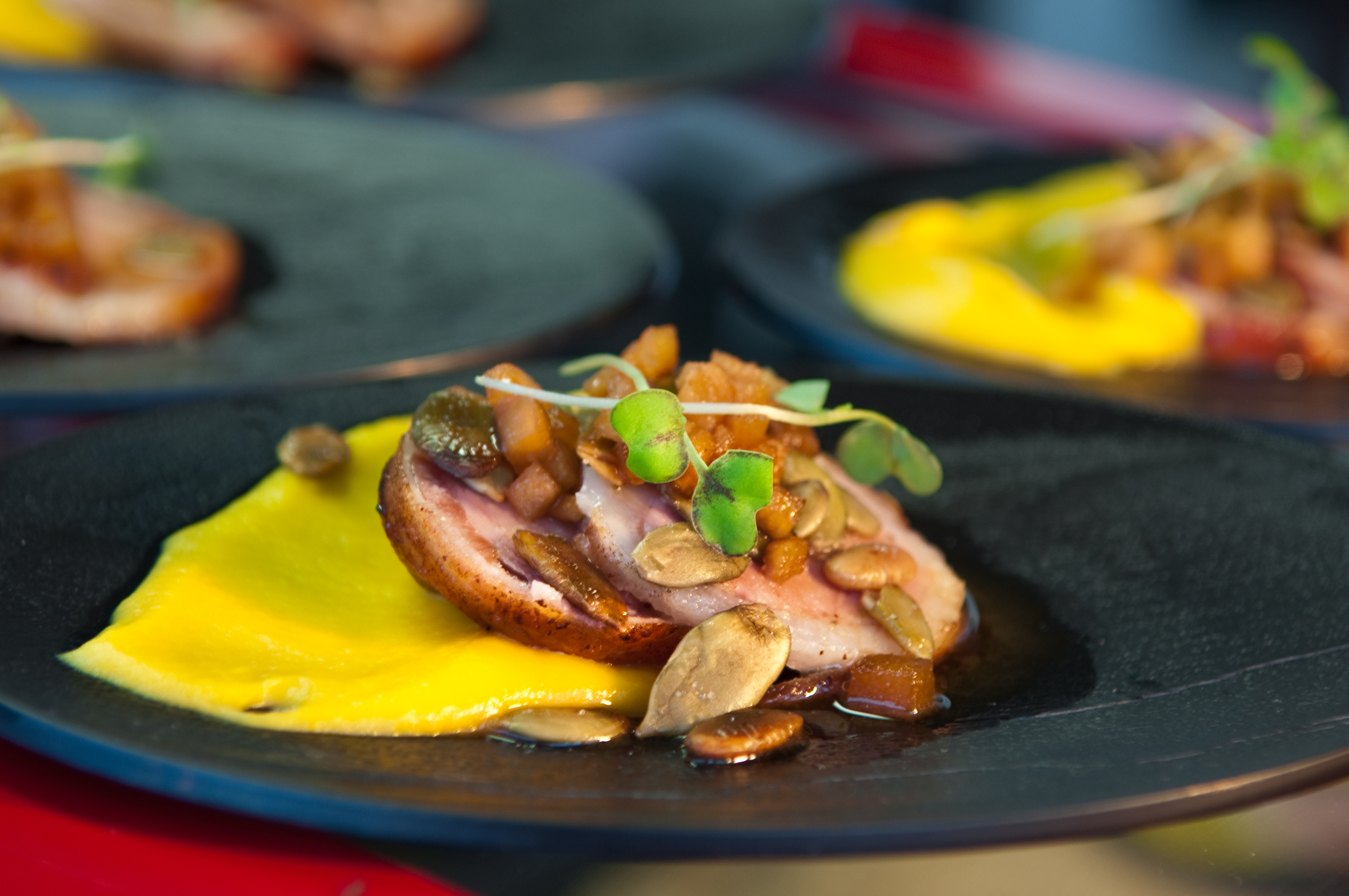 Plates of food garnished with leaves rest ready for a event.