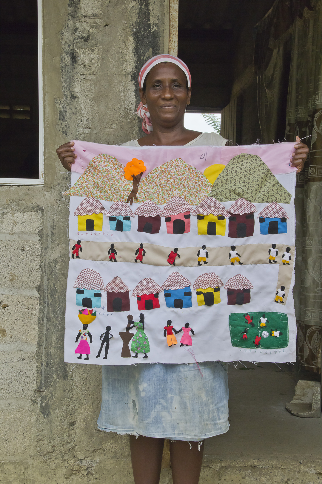  Here a woman is showing her woven fabric artwork representing the idea of community integration, her love for the sports and her attachment to cultural traditions 