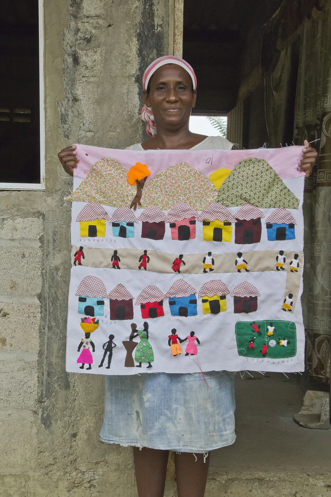 Here a woman is showing her woven fabric artwork representing the idea of community integration, her love for the sports and her attachment to cultural traditions