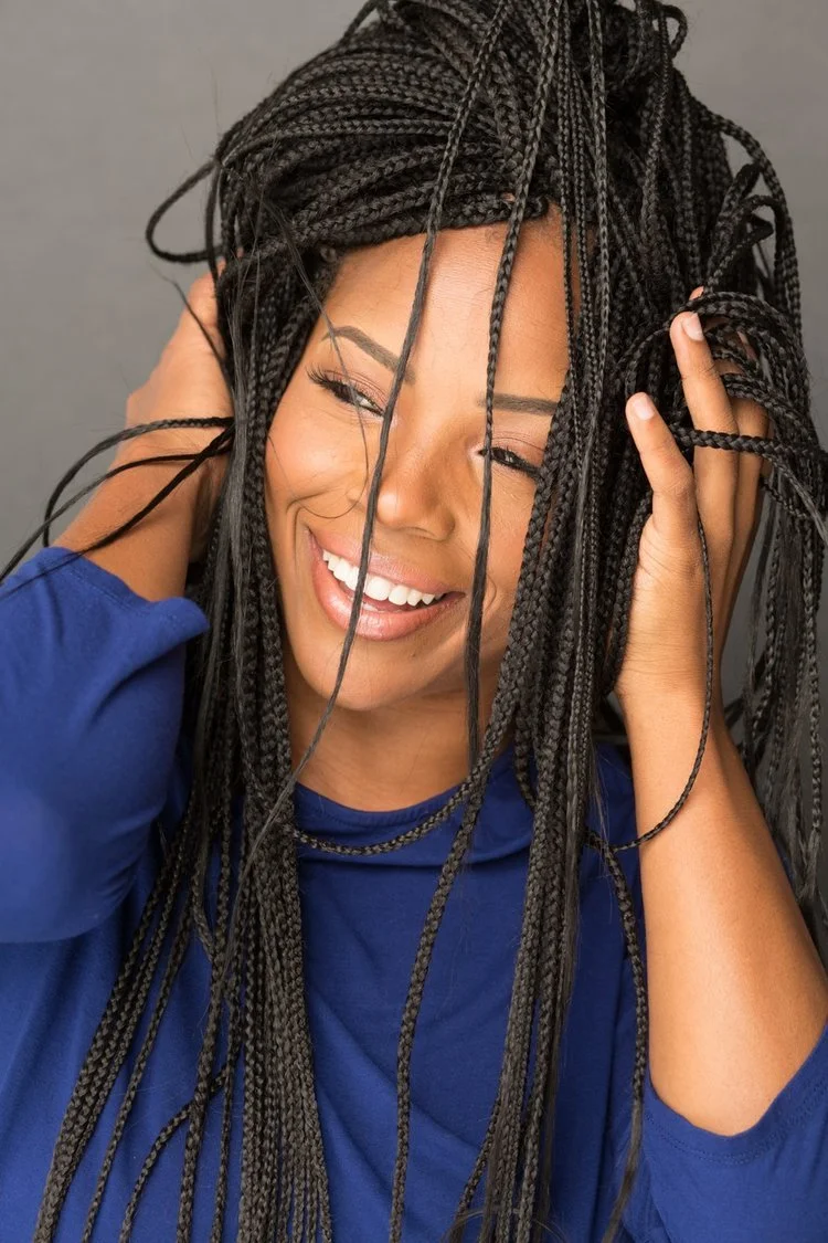 Tierra Destiny Reid laughing, hands lifted into her braids