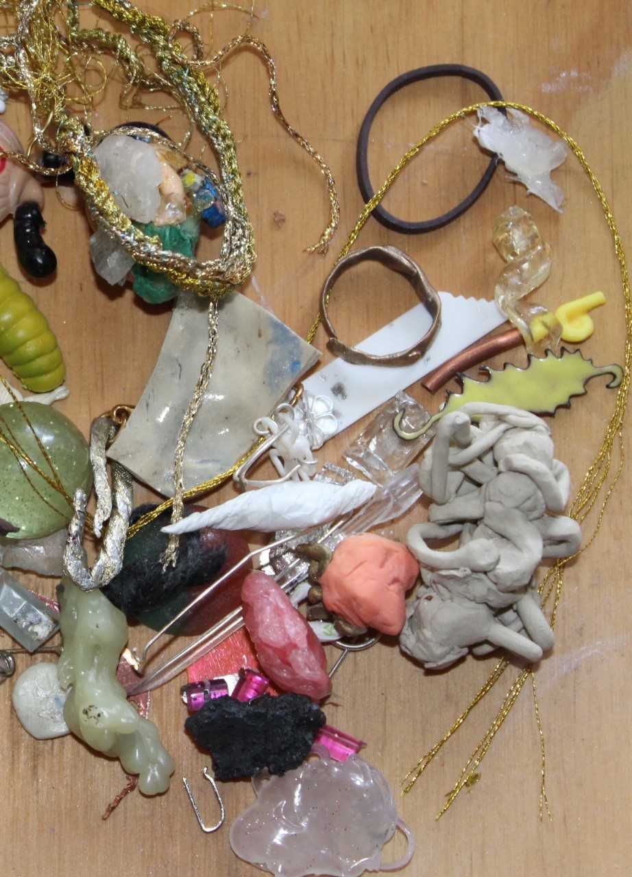 image details: Audrey Tan, untitled, 2019. broccolini rubber band, thread, dried glue, resin twist, silly onion magnet, half a plastic worm, 2 x half bouncy balls, baci foil, wax, twisted paper, silver wire, sock clip, smashed chrysoprase, smashed ceramic, shopkin, dried chewy, copper tube, plastic flower, enamelled spiky thing
