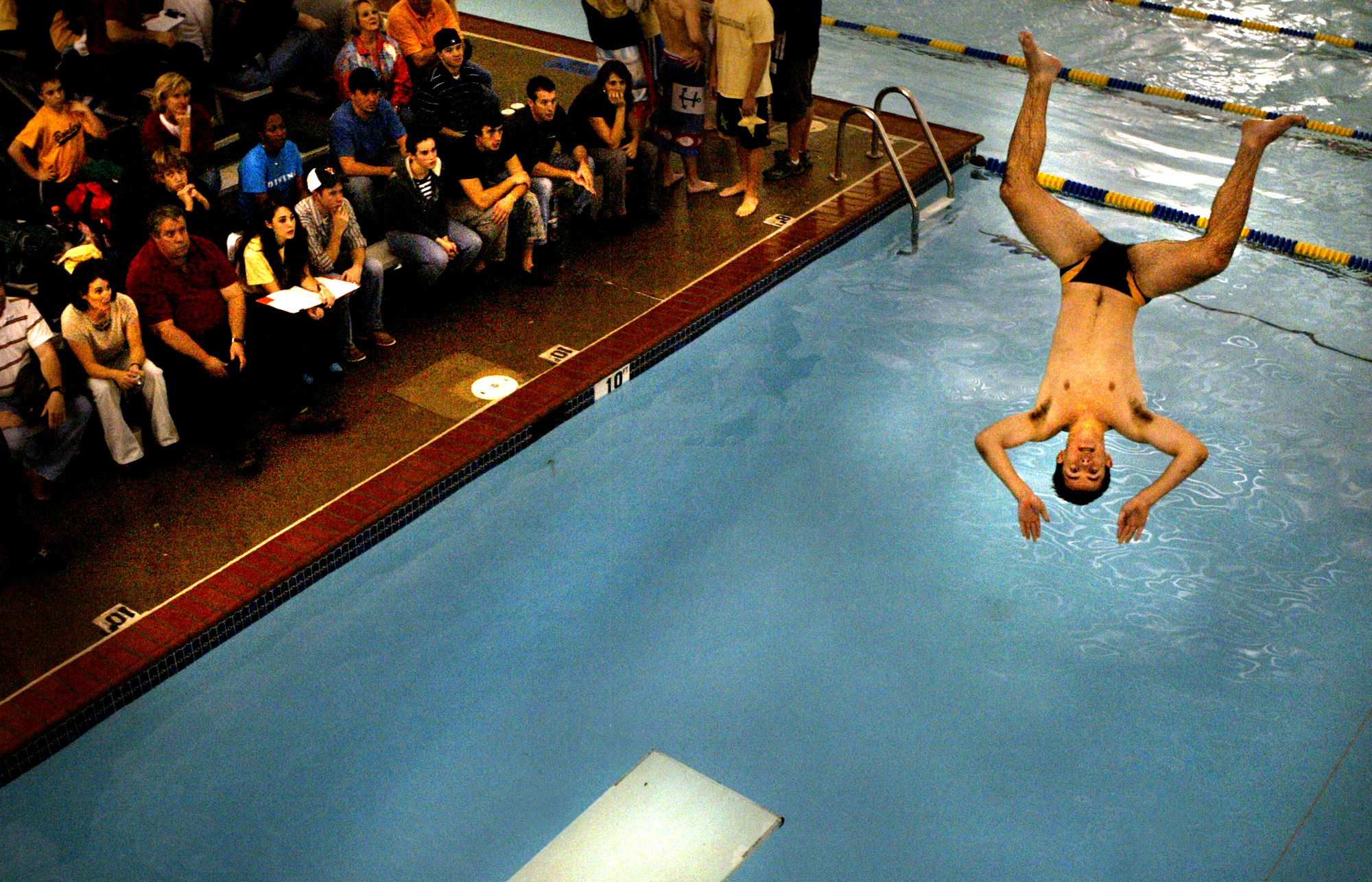 Great Bridge's Conrad Edler performs off of the diving board during their district meet.
