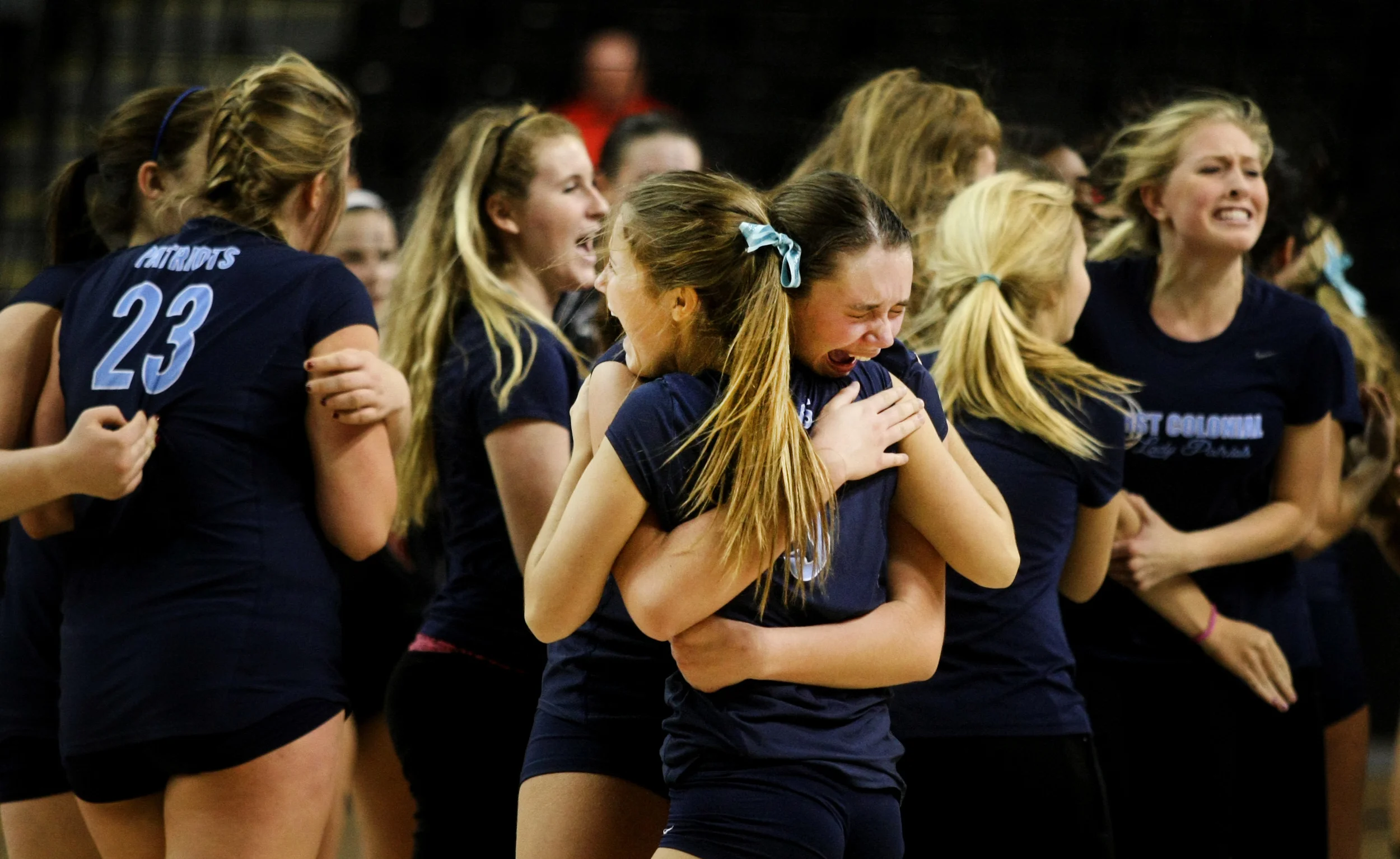 First Colonial's Rowan Ennis, center with face, and teammate Emily Guimond embrace after First Colonial beat James Madison in five-sets to claim the Group 6A girls volleyball championship, Friday, Nov. 21, 2014 at the Siegel Center in Richmond. (Jason Hirschfeld | For The Virginian-Pilot)