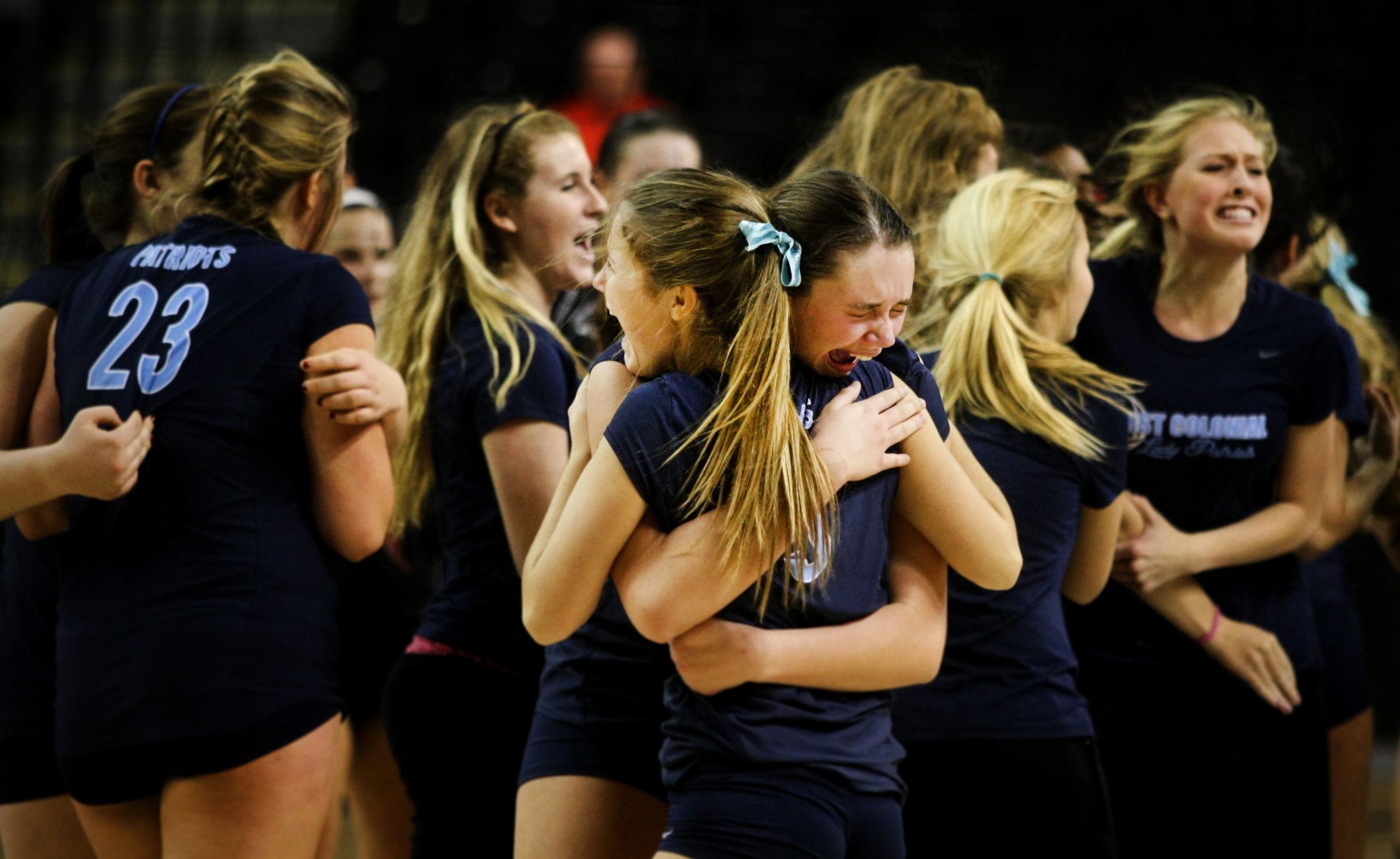 First Colonial's Rowan Ennis, center with face, and teammate Emily Guimond embrace after First Colonial beat James Madison in five-sets to claim the Group 6A girls volleyball championship.