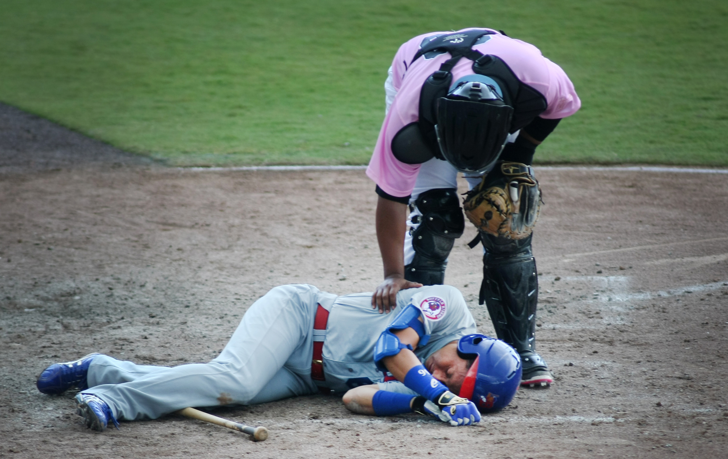 Tides catcher Audry Perez tends to Buffalo's Munenori Kawasaki as he lays motionless after getting drilled in the head with a fastball in the top of the seventh inning. Kawasaki remained on the ground for several minutes but was then helped off the field, Sunday, May 10, 2015 at Harbor Park in Norfolk. 